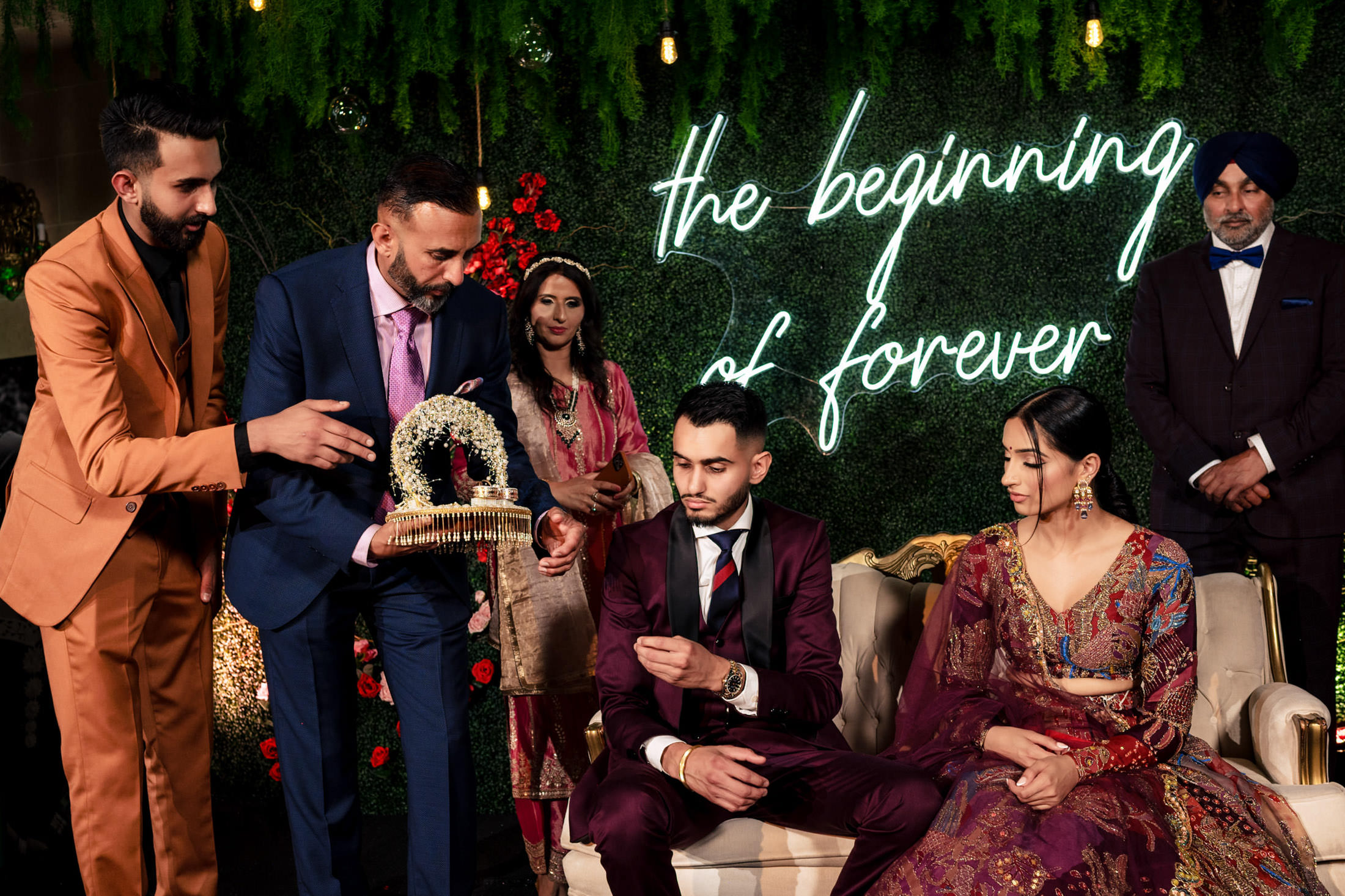 A couple in formal attire sits at their Winnipeg engagement ceremony.