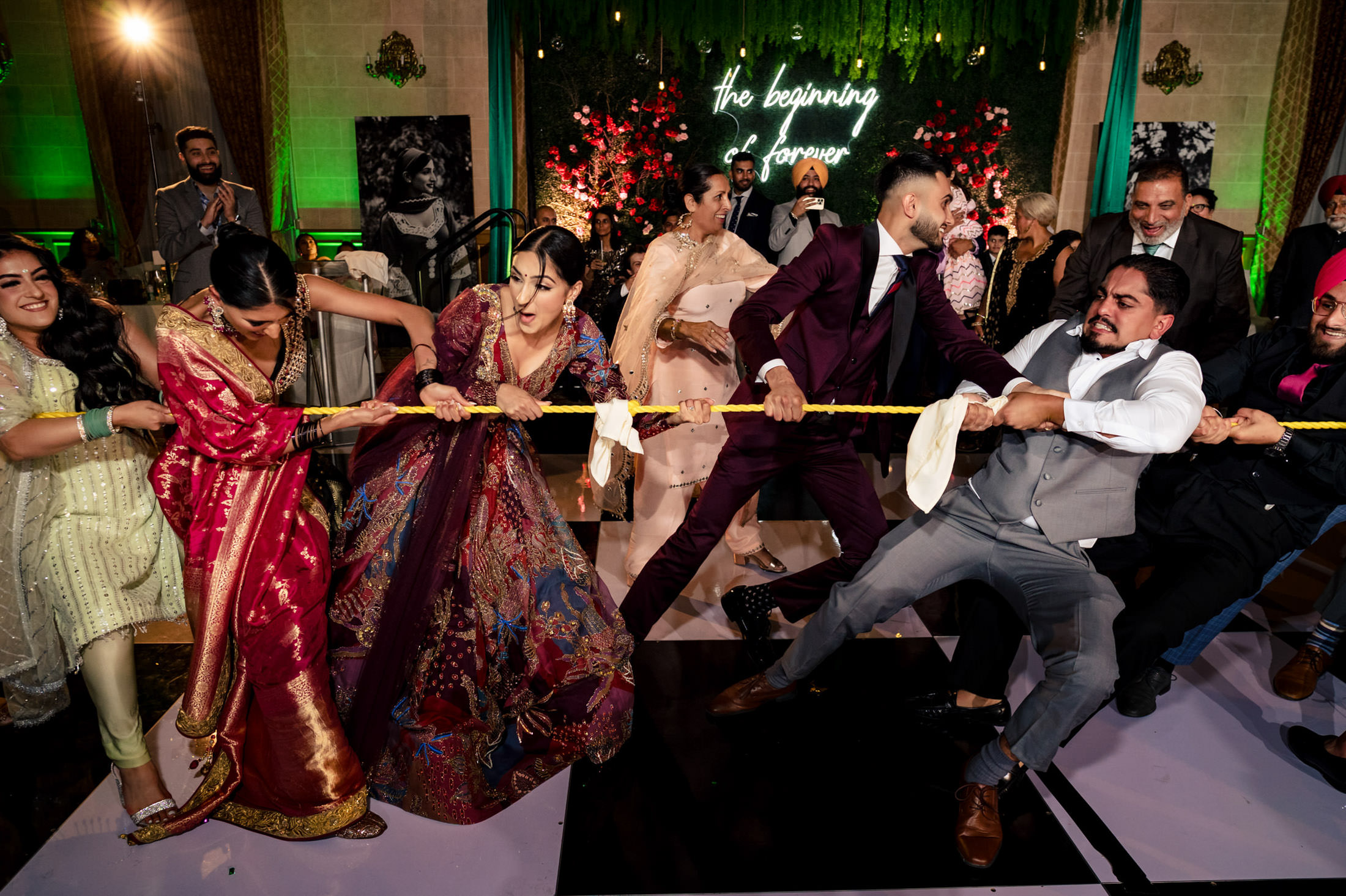 People in formal attire play tug-of-war at a lively Winnipeg wedding event.