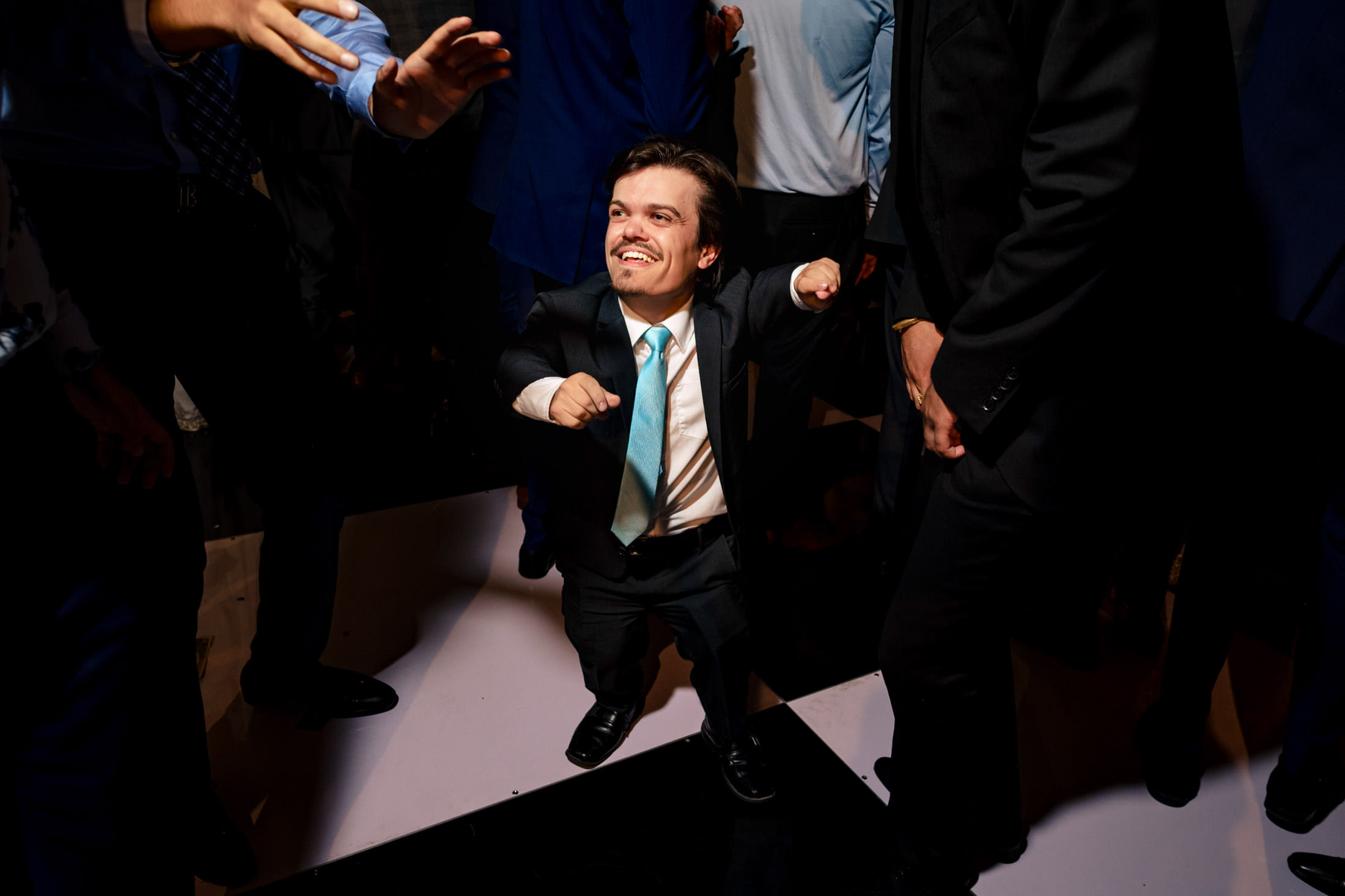 A man in a suit joyfully dances at a lively Winnipeg wedding.