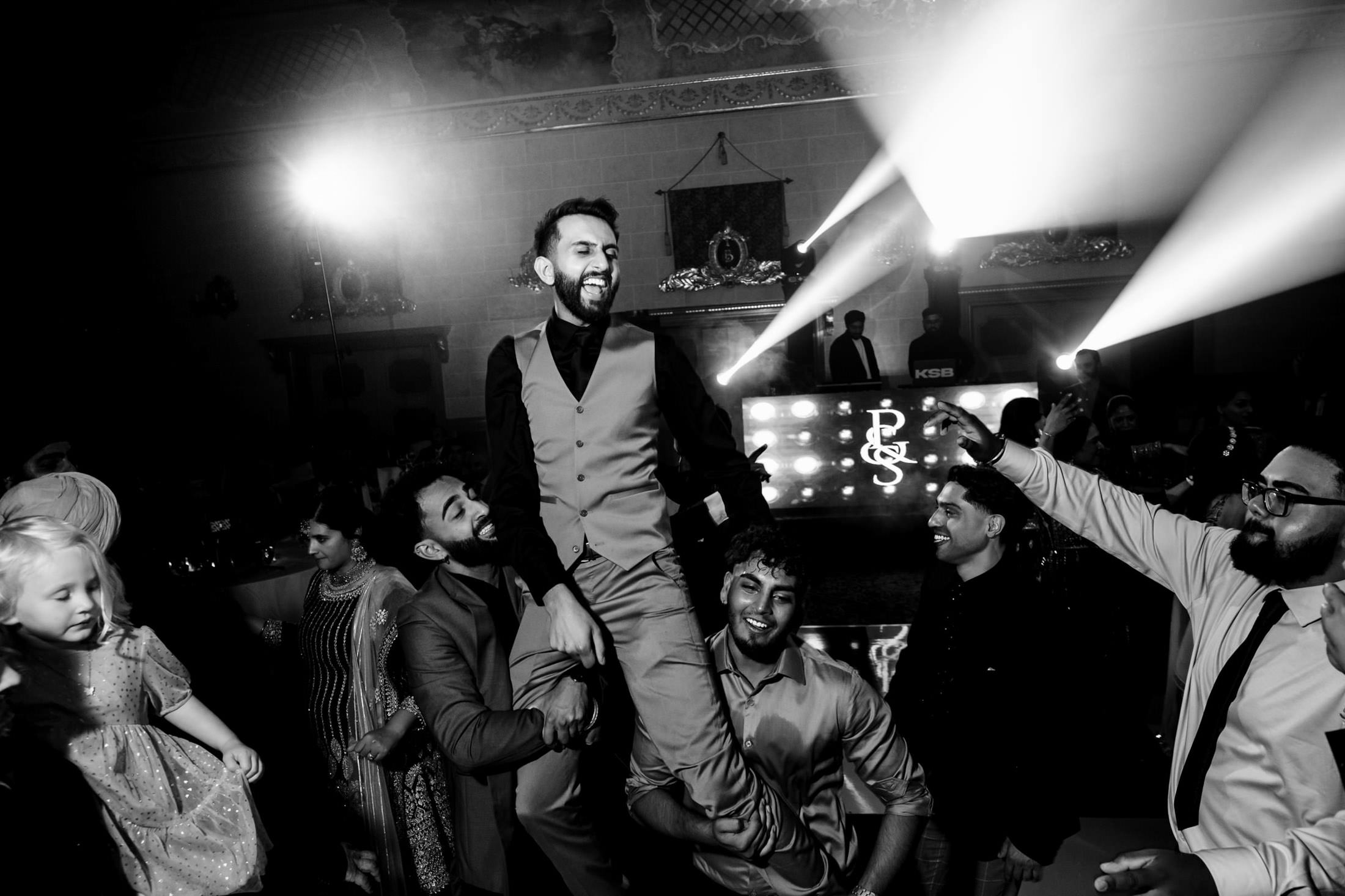 A festive Winnipeg wedding with people dancing and lifting a smiling man.
