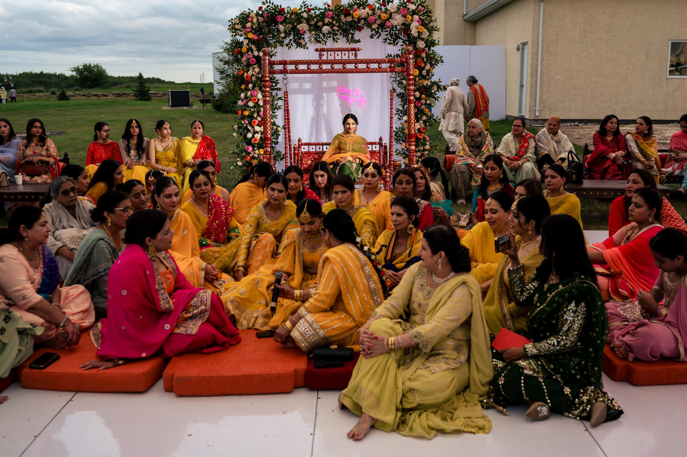 A Winnipeg wedding with people in colorful traditional attire and decorative flowers.