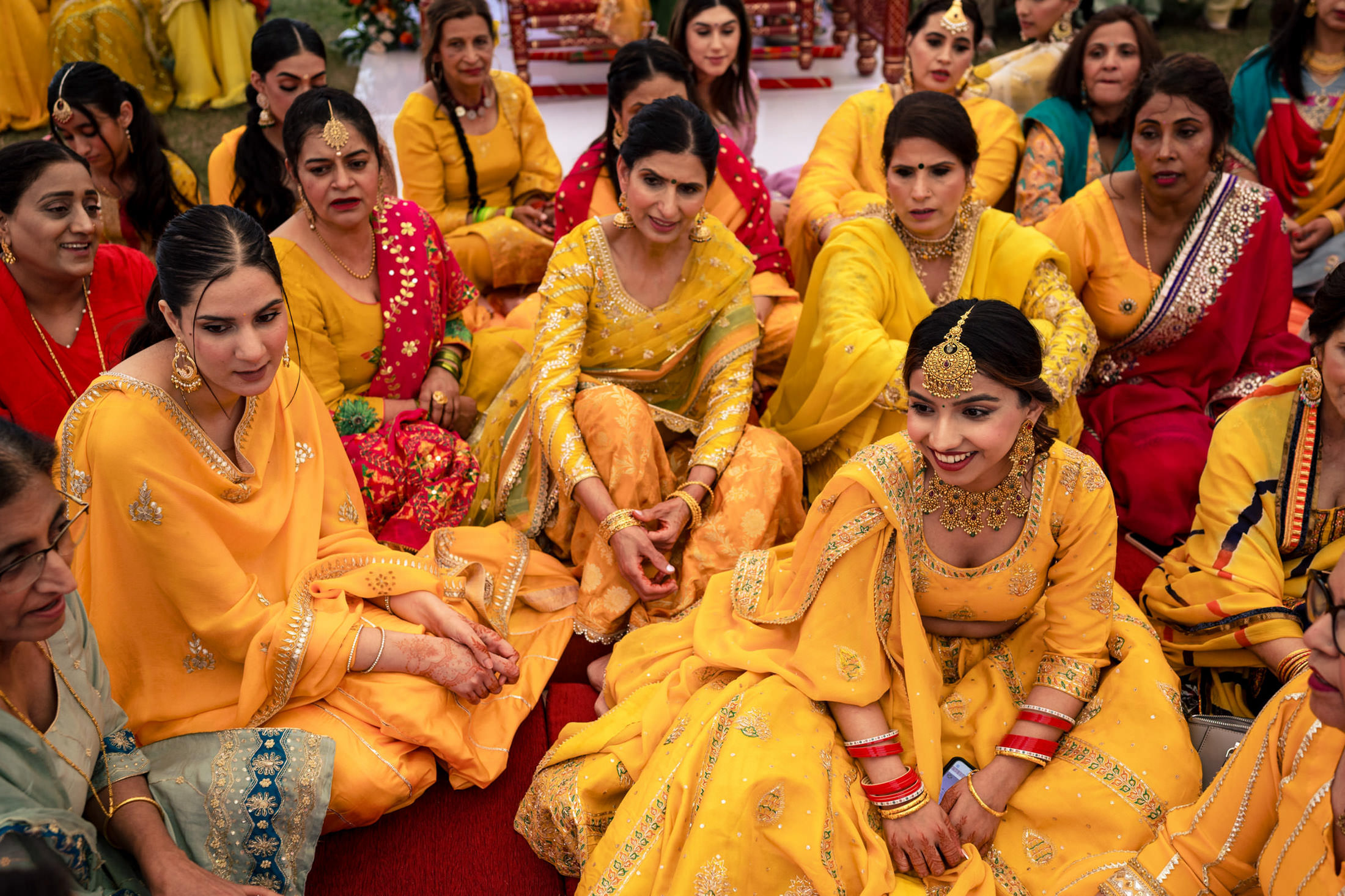 Women in colorful traditional attire smile together at a vibrant Winnipeg wedding.