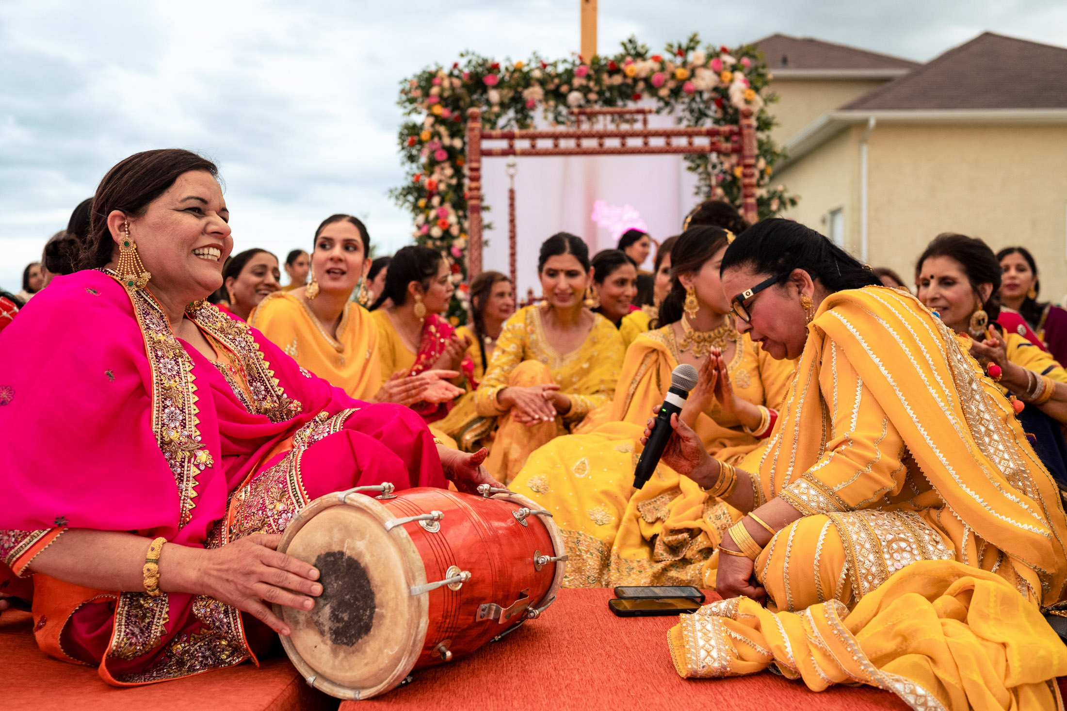 Group of women in colorful traditional attire singing and drumming at a Winnipeg wedding.