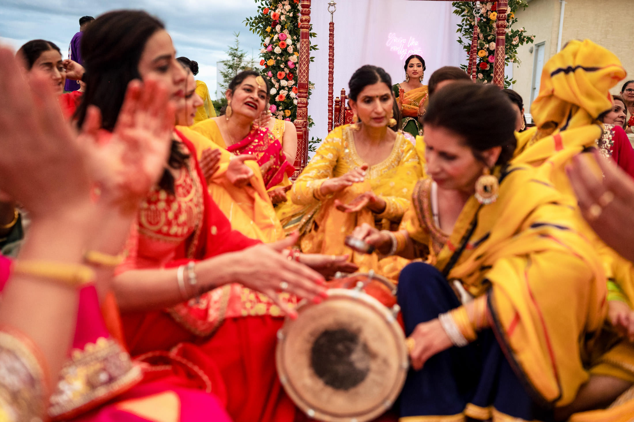 People in vibrant traditional attire celebrate with music at a Winnipeg wedding event.