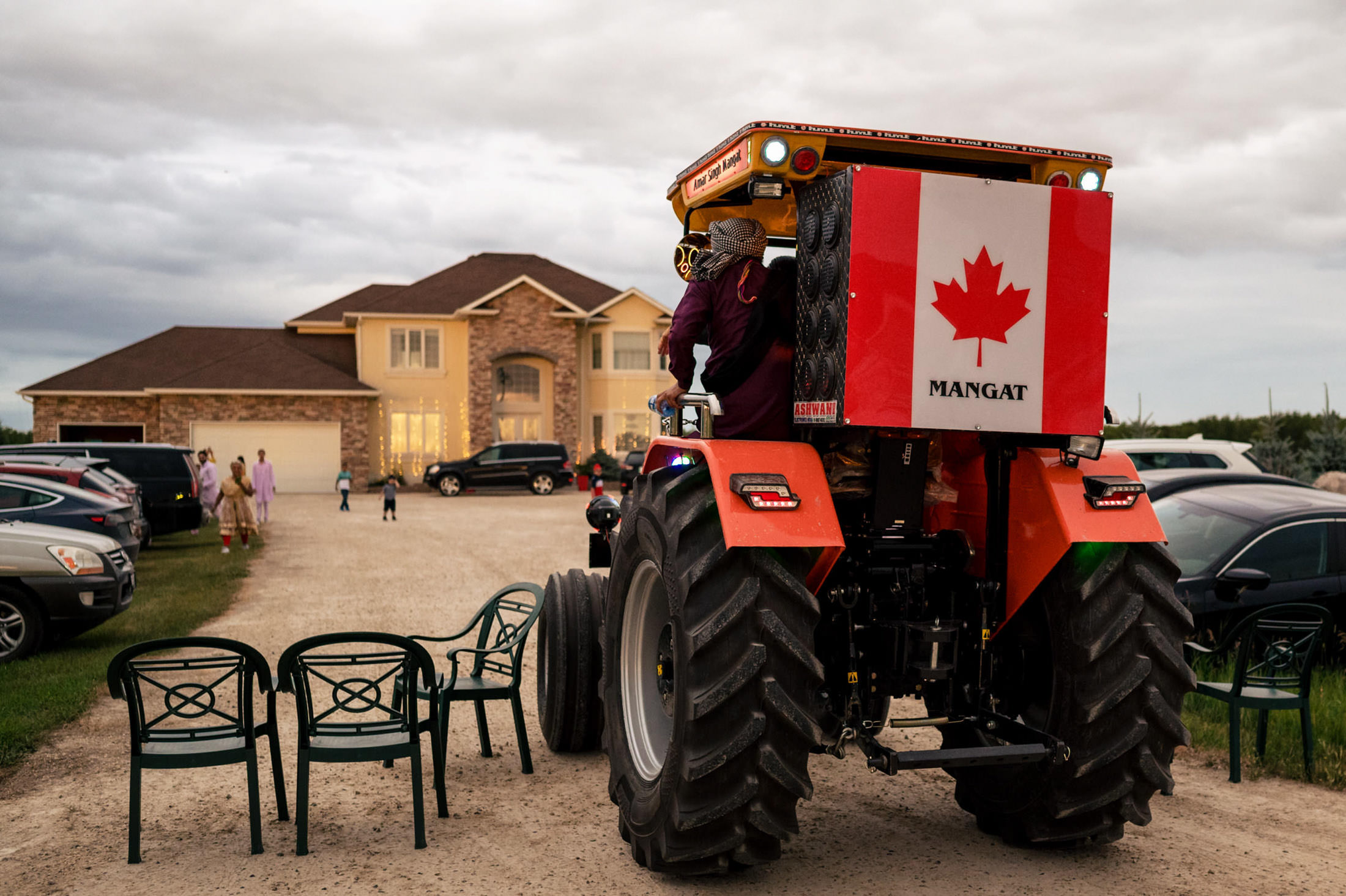 A tractor with a Canadian flag parked on a driveway, ready for a Winnipeg wedding.
