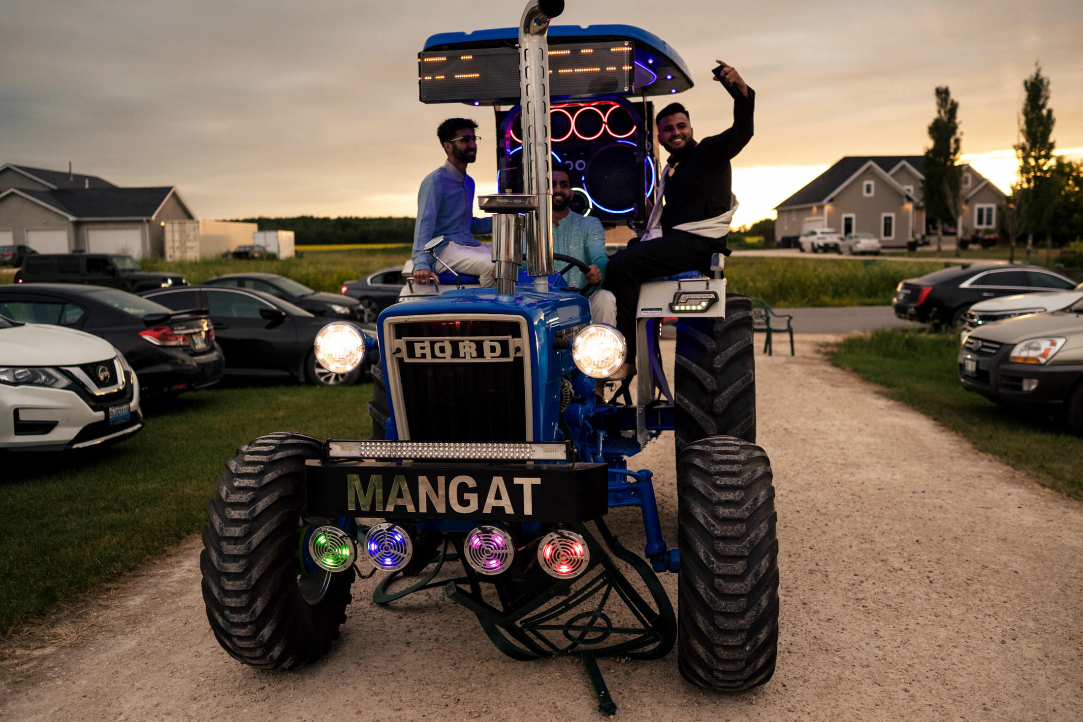 People on a blue tractor with colorful lights, perfect for a Winnipeg wedding setting.