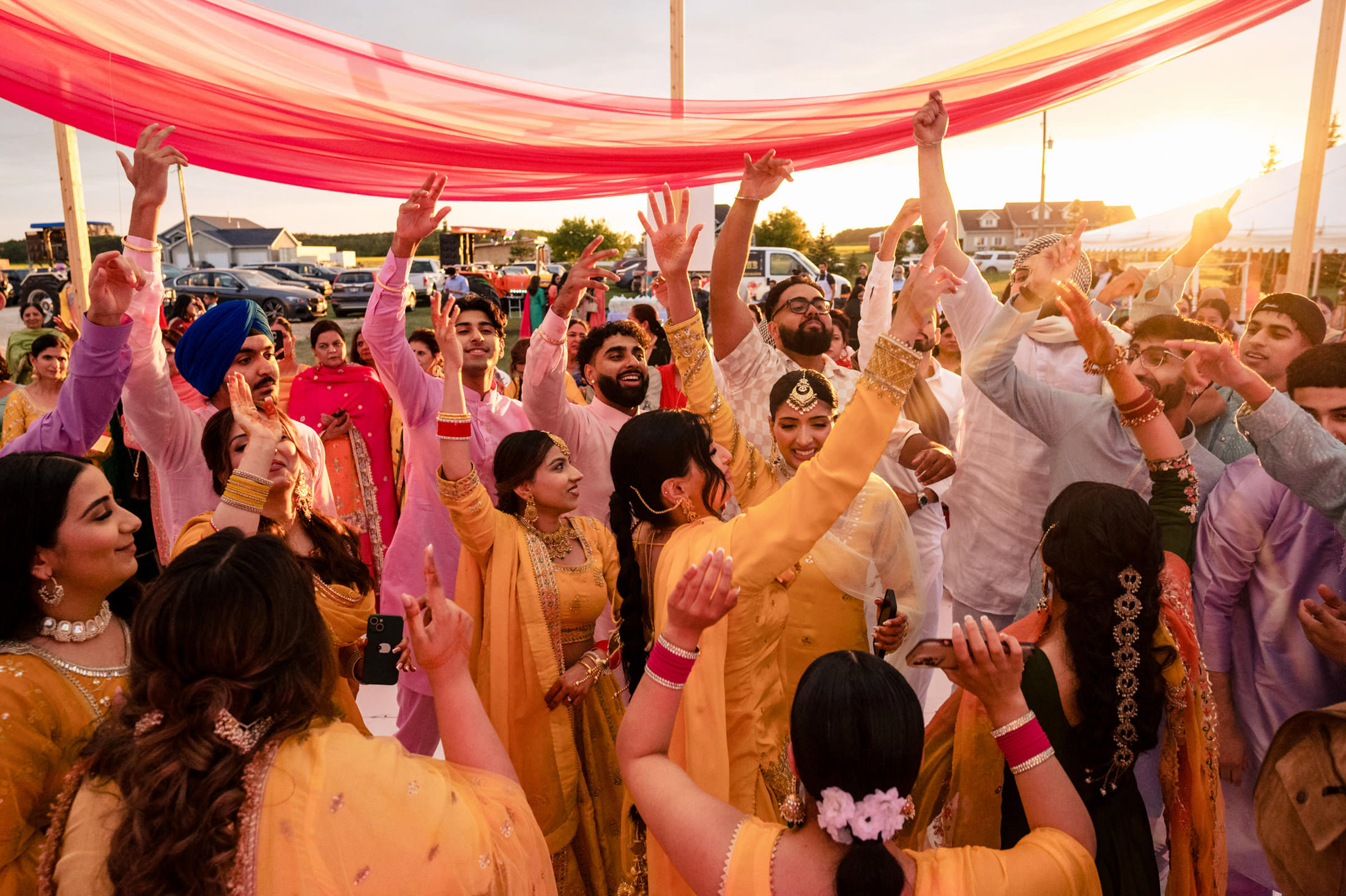 Joyful dancing under a pink canopy at a vibrant Winnipeg wedding celebration.