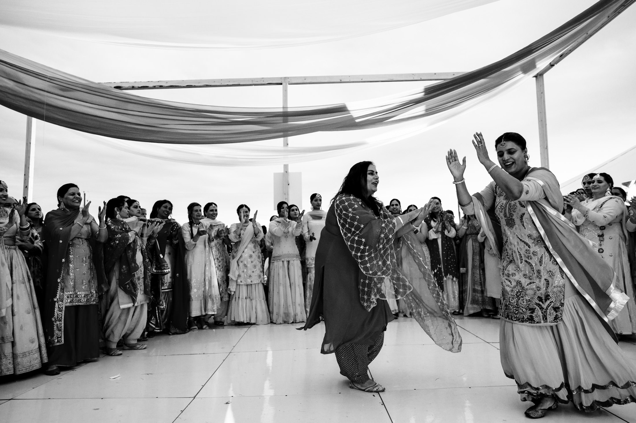 Group of people in traditional attire dancing at an outdoor Winnipeg wedding celebration.