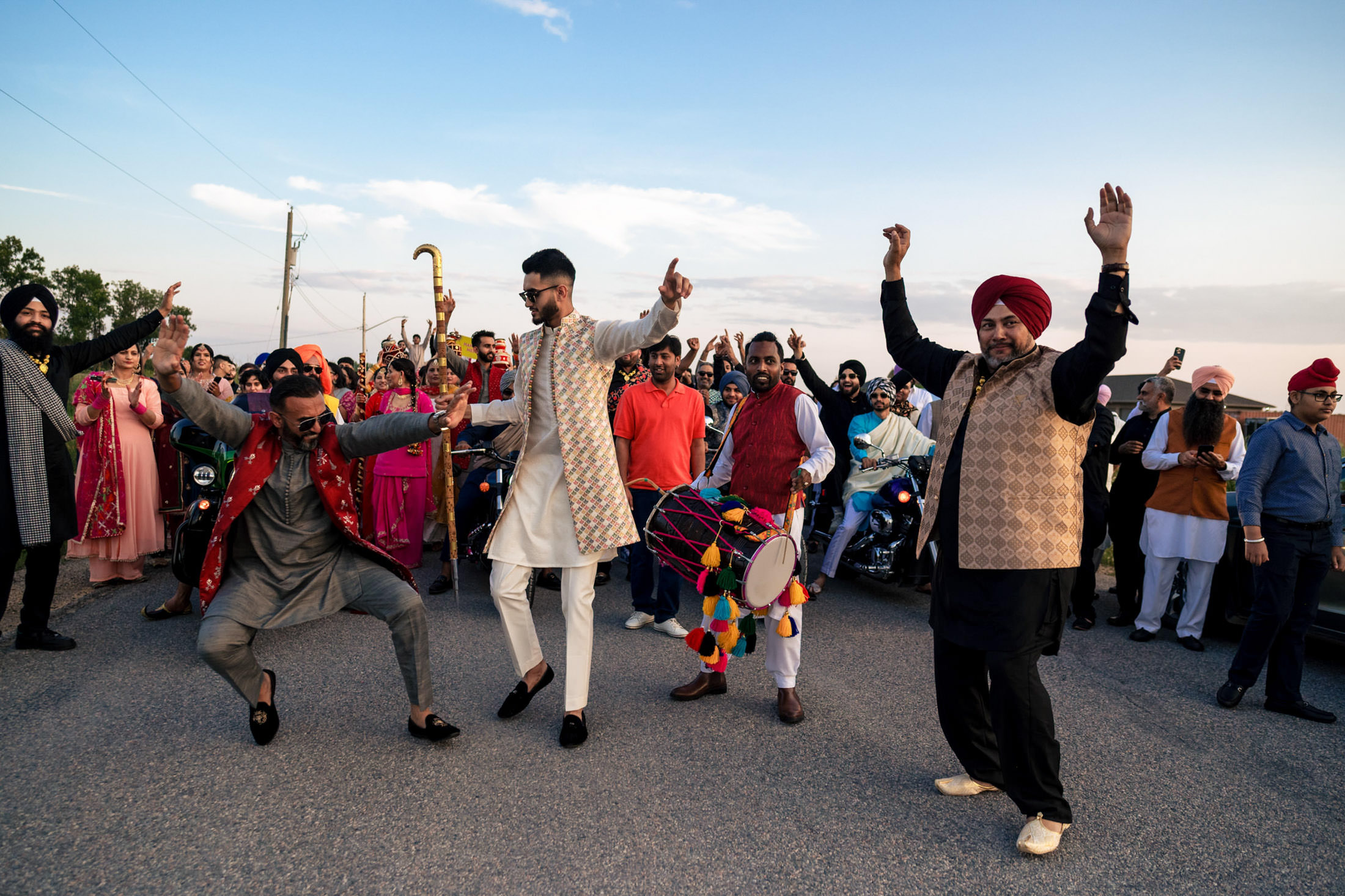 People dancing energetically in traditional attire at a festive Winnipeg wedding.