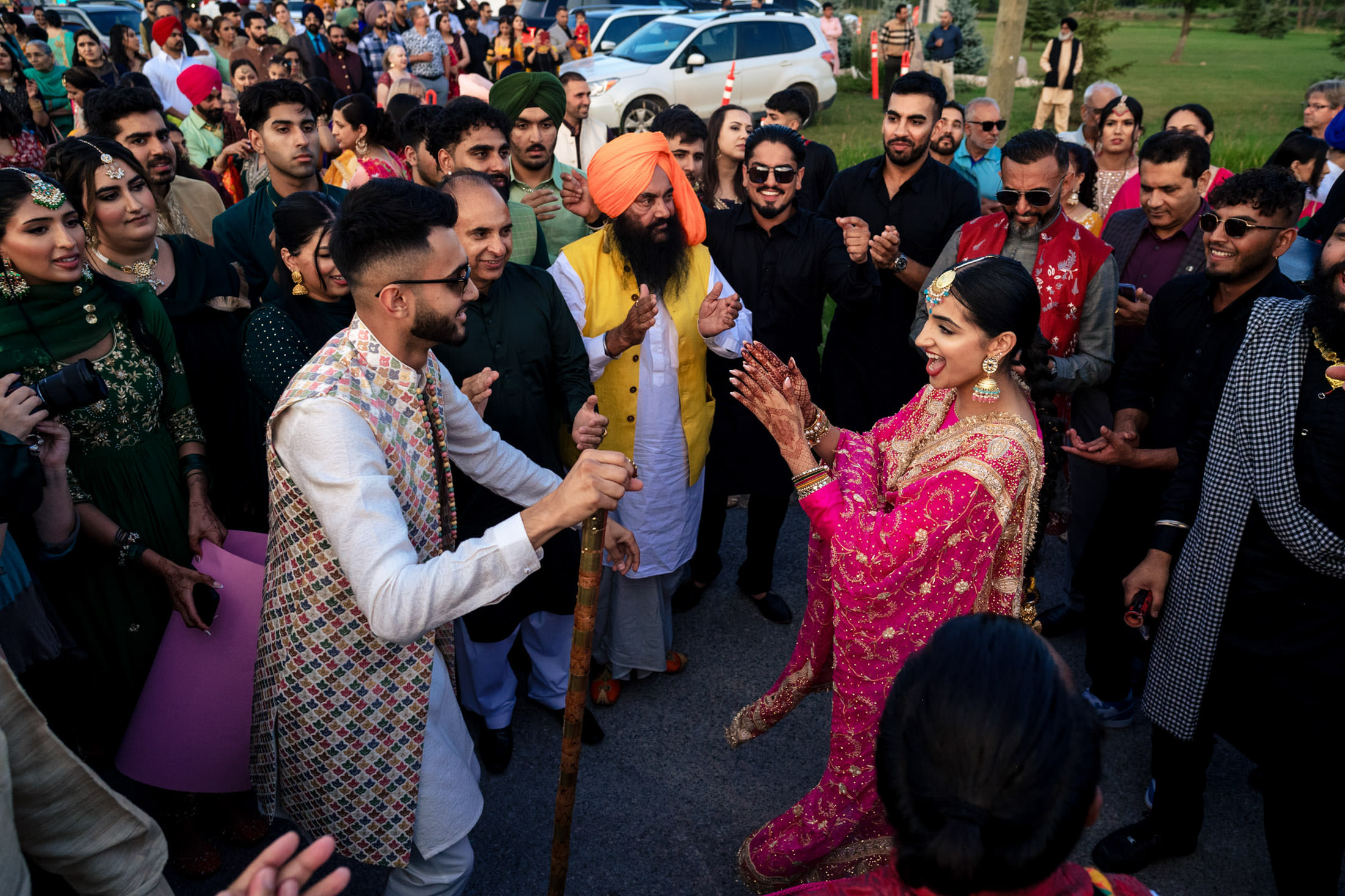 A joyful couple dances in traditional attire at a lively Winnipeg wedding.