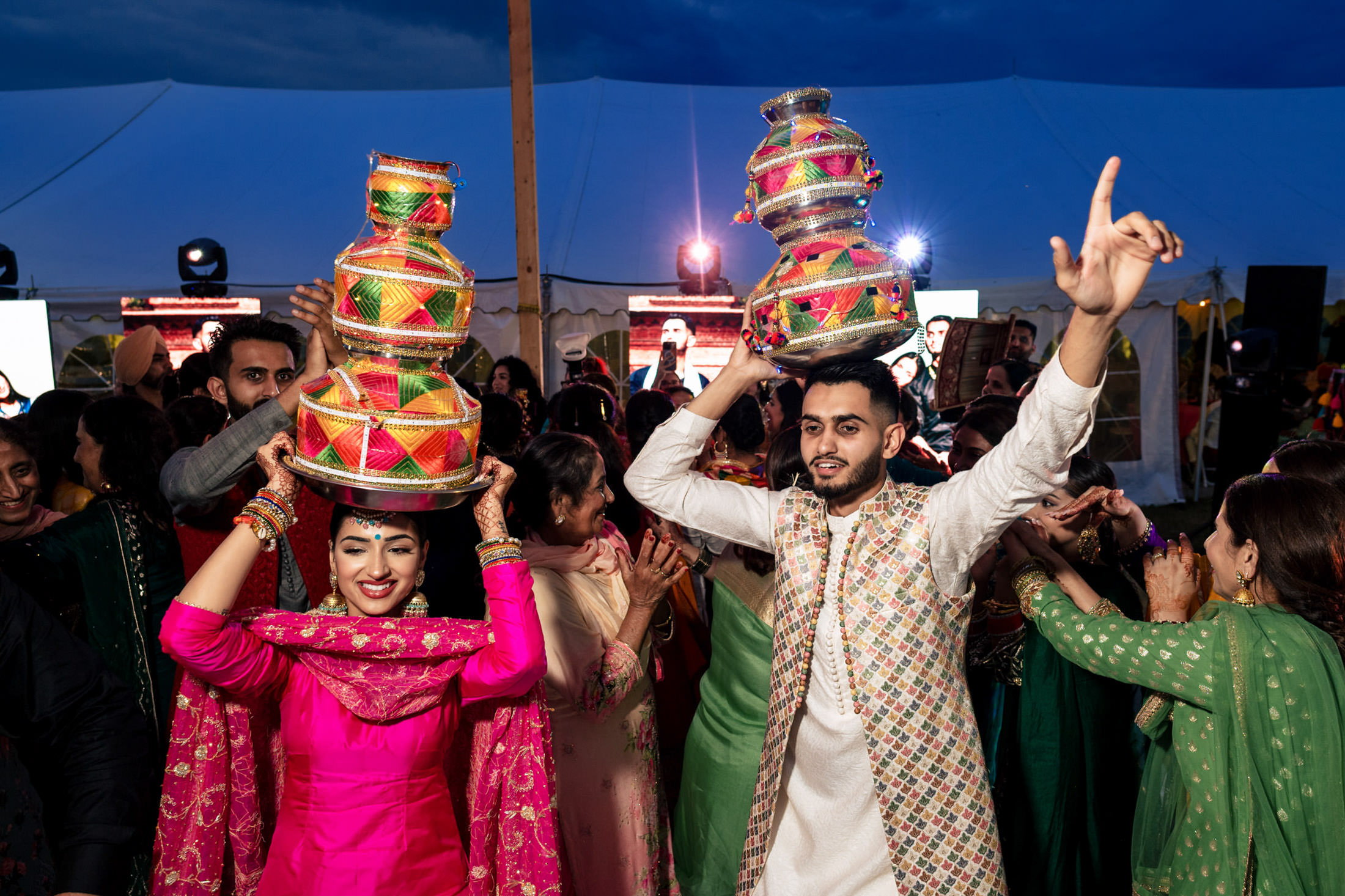 A couple dances with colorful pots on their heads at a Winnipeg wedding.