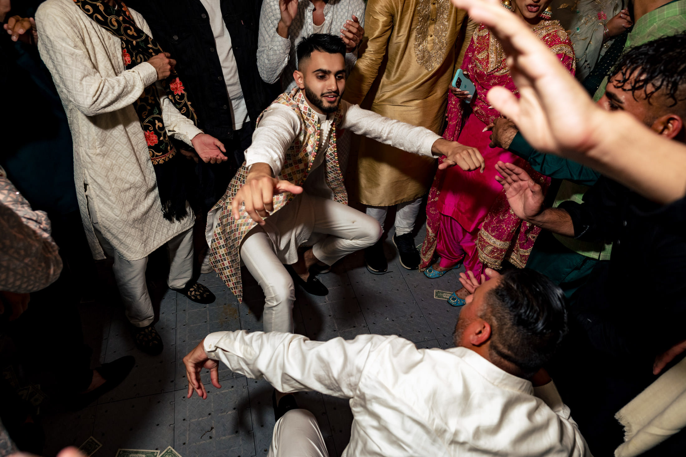 Guests dancing energetically at a Winnipeg wedding, wearing colorful traditional attire.
