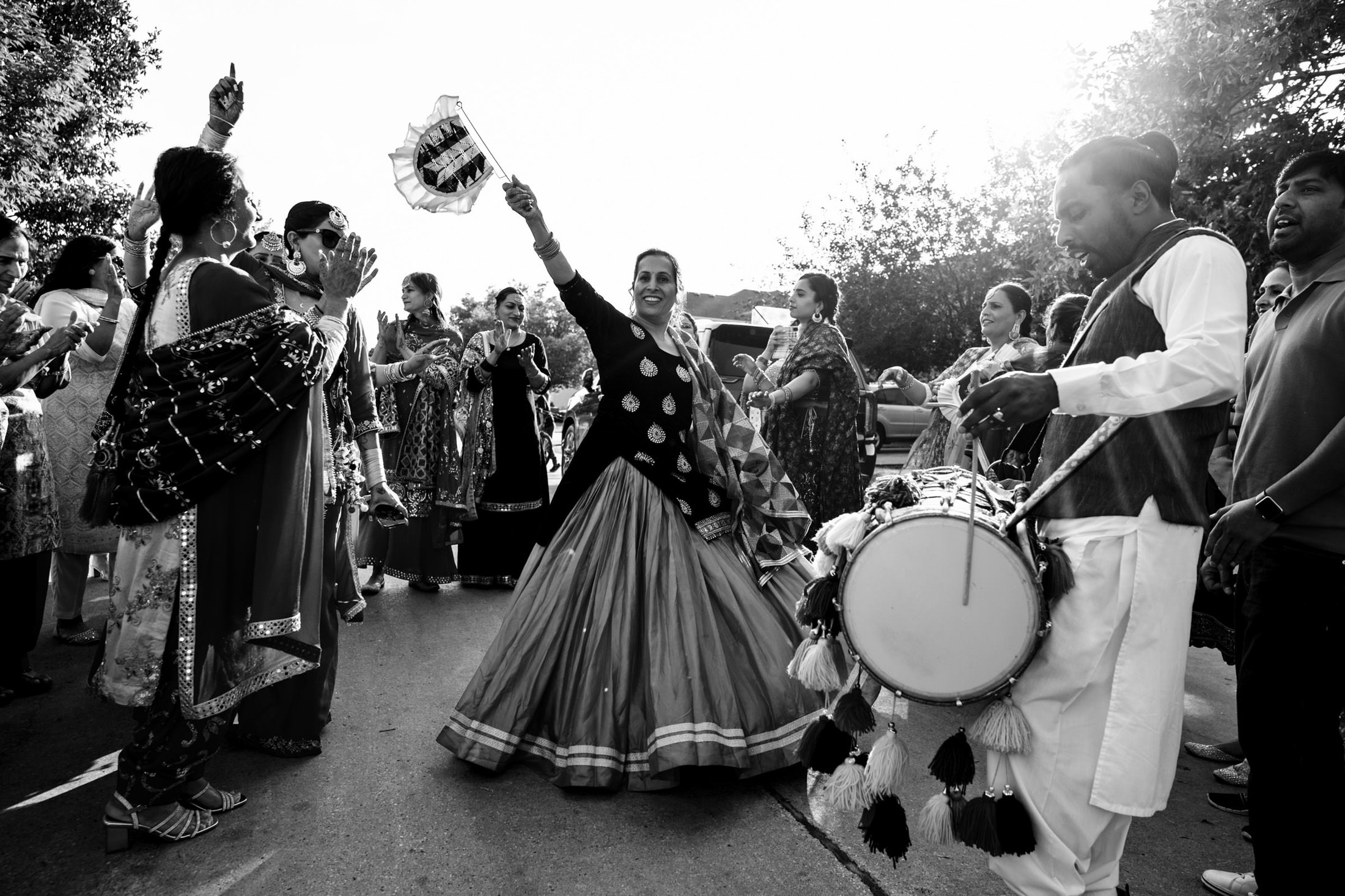 A dancer leads a vibrant Winnipeg wedding procession with drummers in traditional clothing.