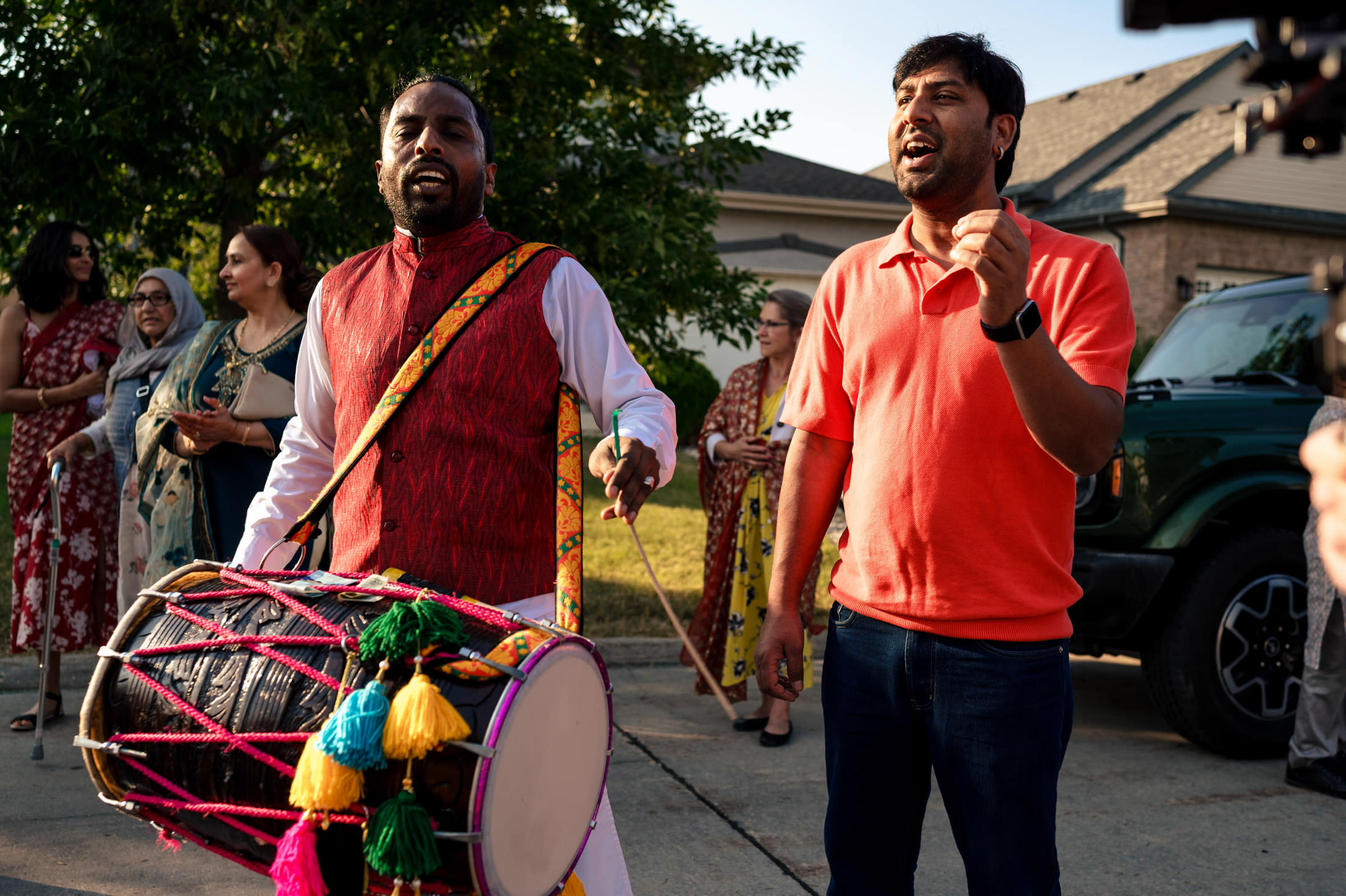 Two men joyfully singing and drumming at a vibrant Winnipeg wedding celebration.