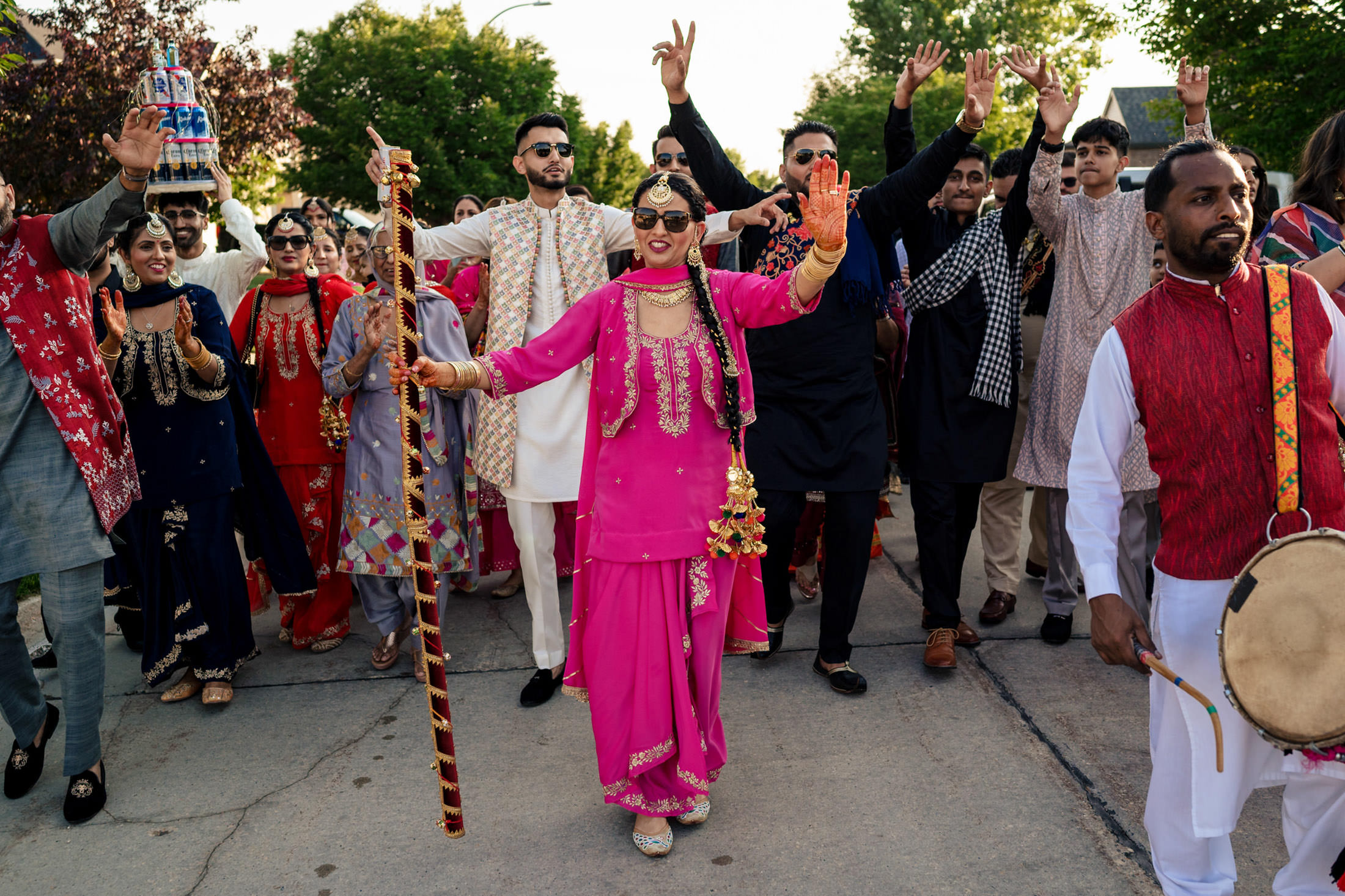 A joyful group dances energetically in colorful attire at a Winnipeg wedding.