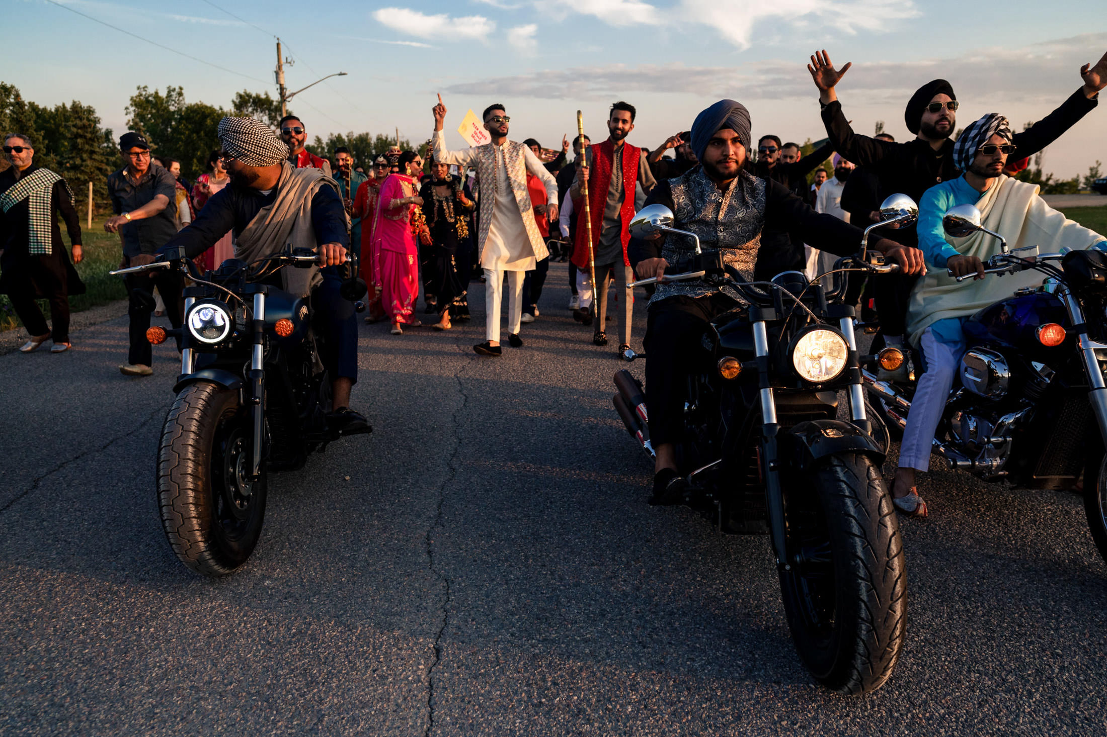 A Winnipeg wedding parade with motorcycles and colorful clothing fills the road.