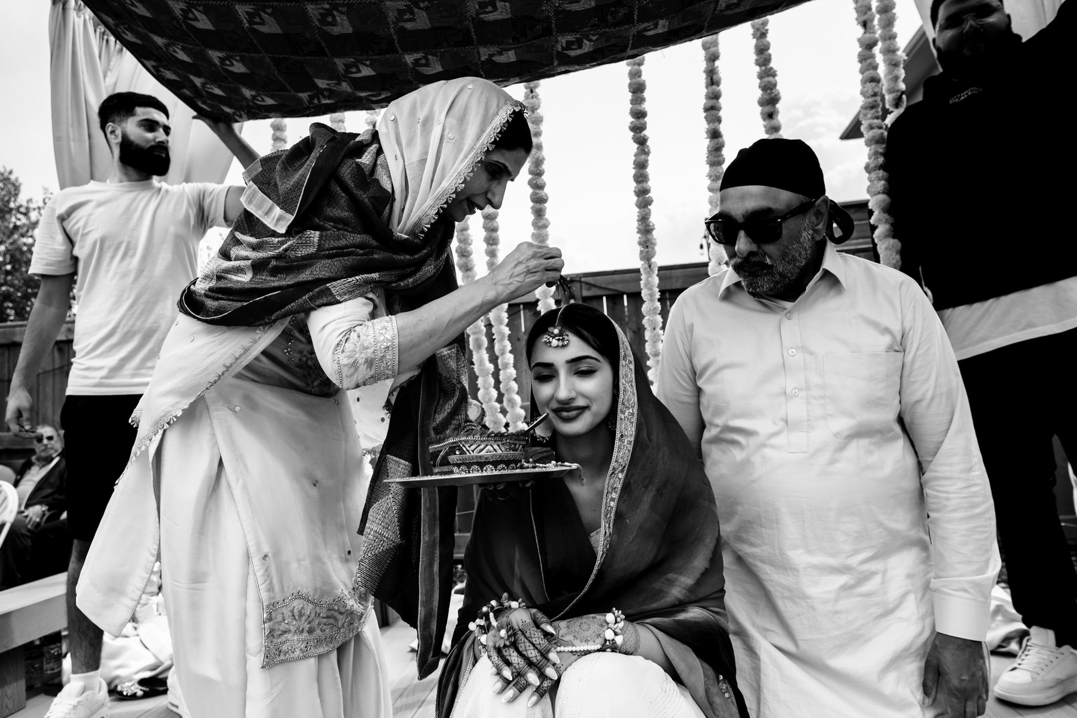 A woman blesses a bride in a Winnipeg wedding ceremony, with onlookers nearby.
