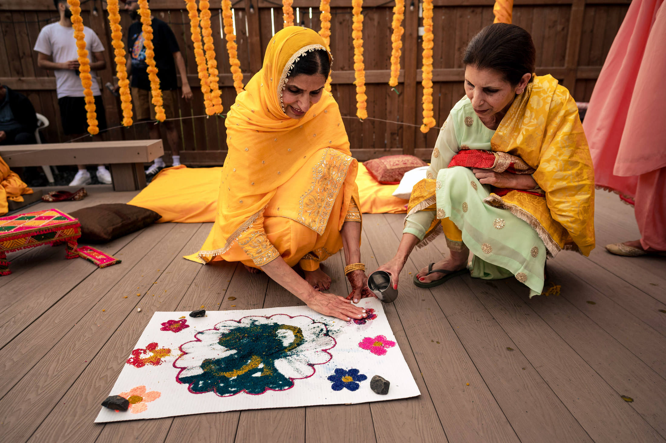 Two women crafting art at a cultural event, reminiscent of a Winnipeg wedding's vibrancy.