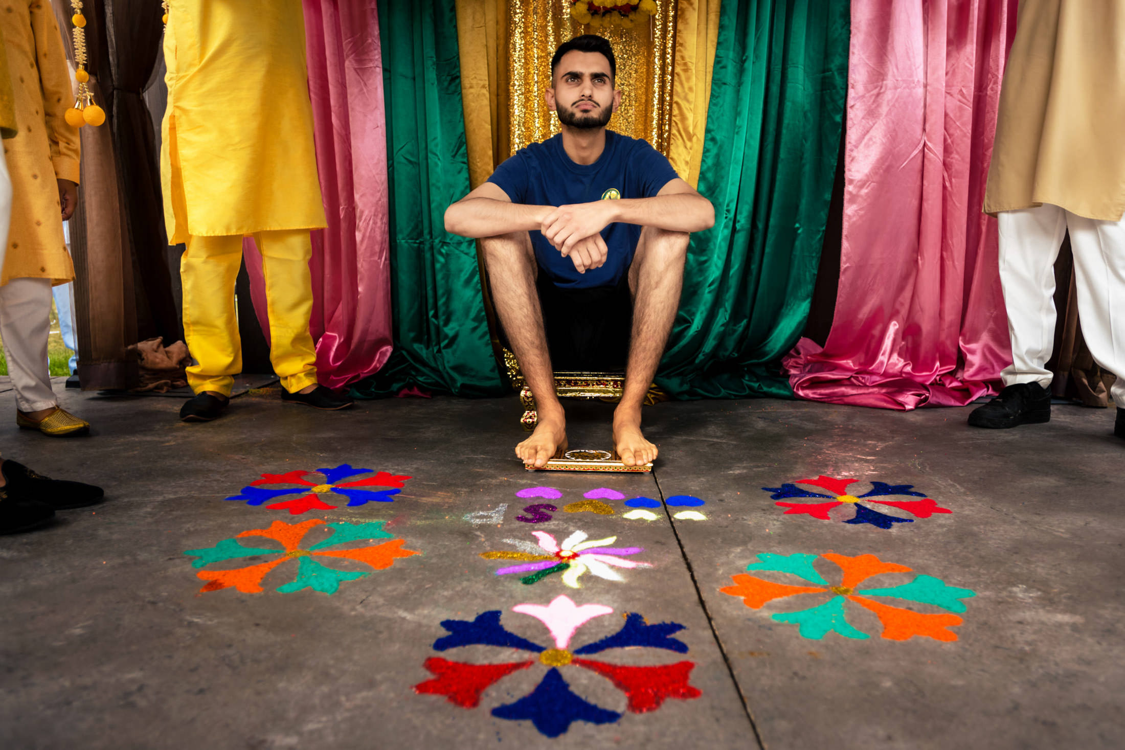 A person sits amid vibrant flower patterns at a colorful Winnipeg wedding backdrop.