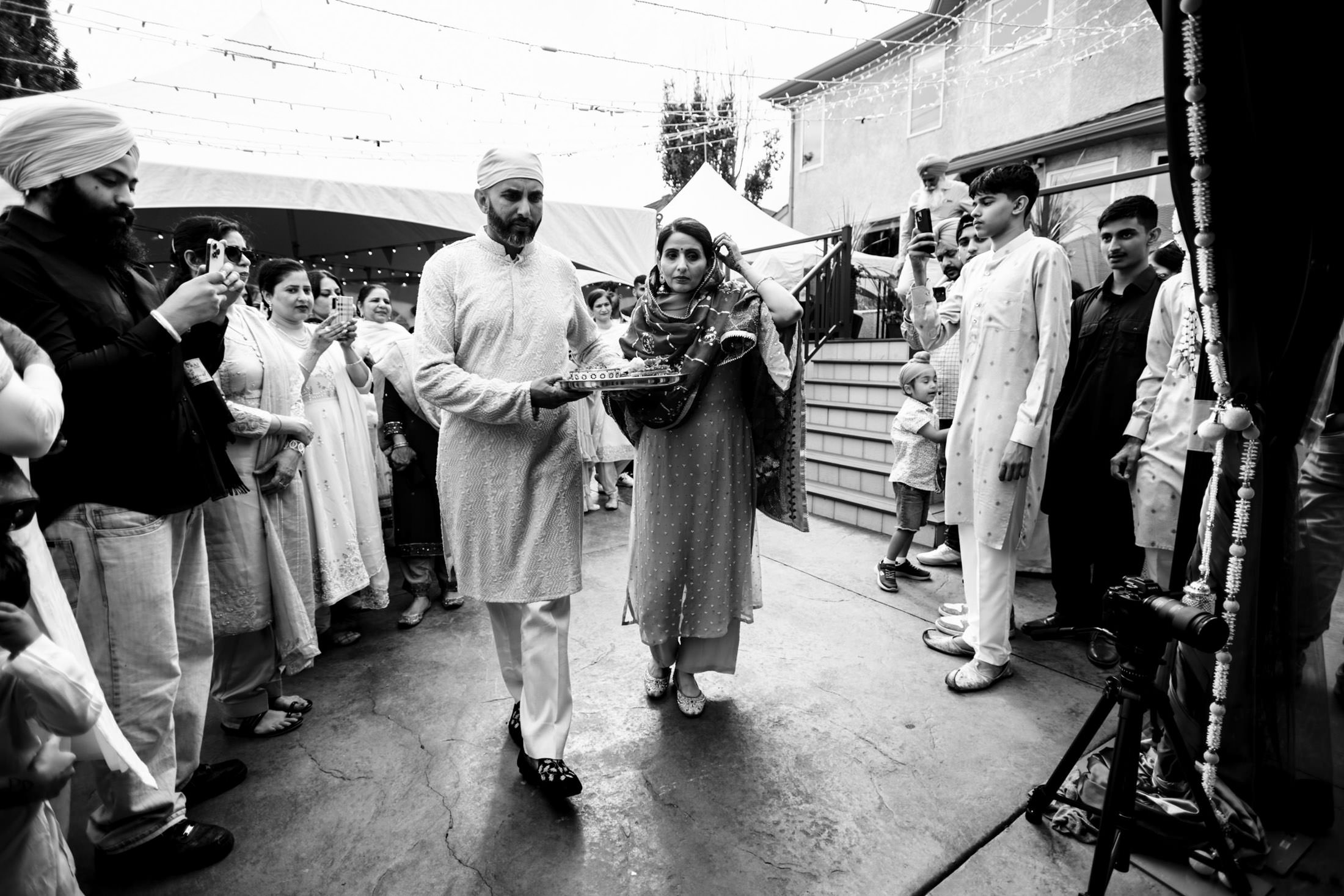 A couple in traditional attire participate in a Winnipeg wedding ceremony surrounded by onlookers.