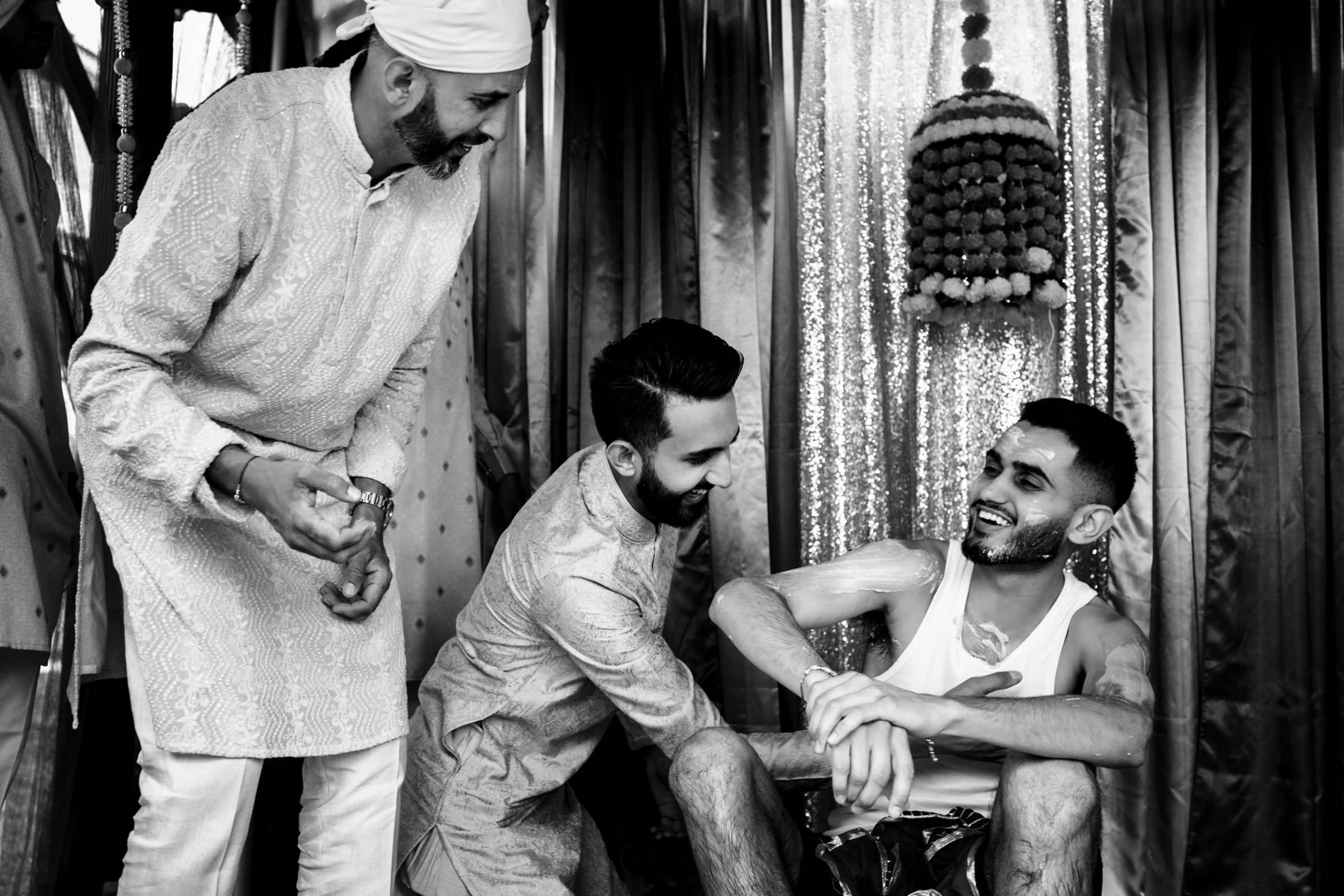 Three men celebrating with joy at a traditional Winnipeg wedding ceremony.