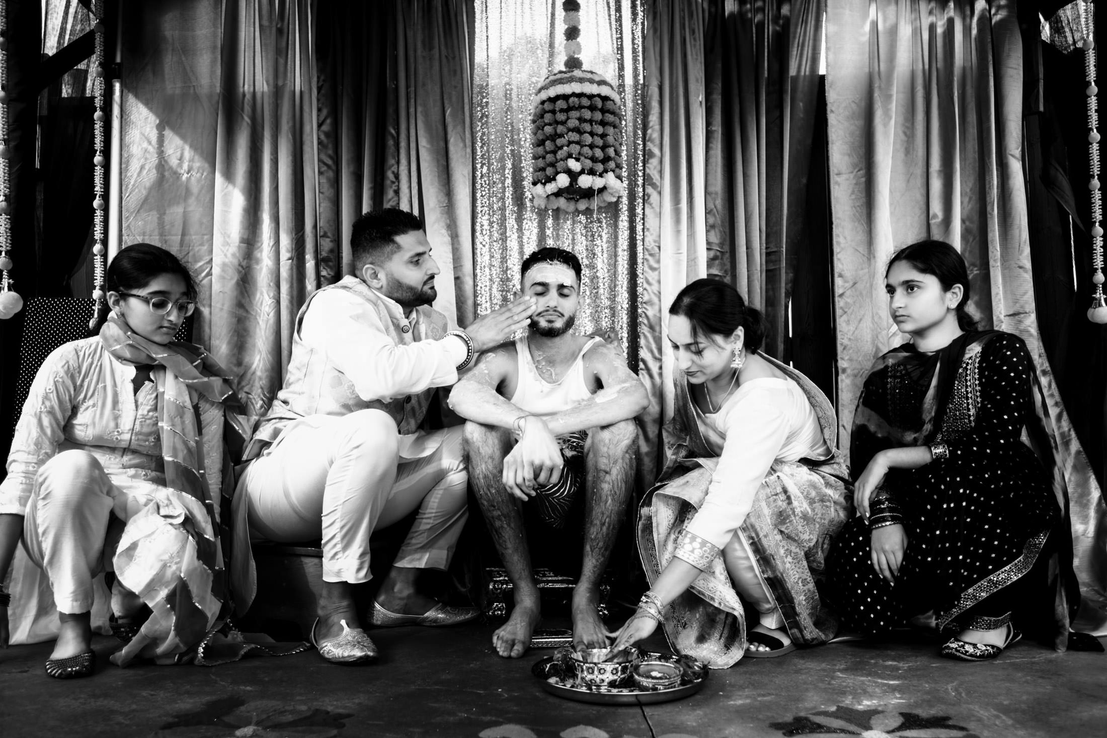 A Winnipeg wedding celebrates a man with rituals, surrounded by people in traditional attire.