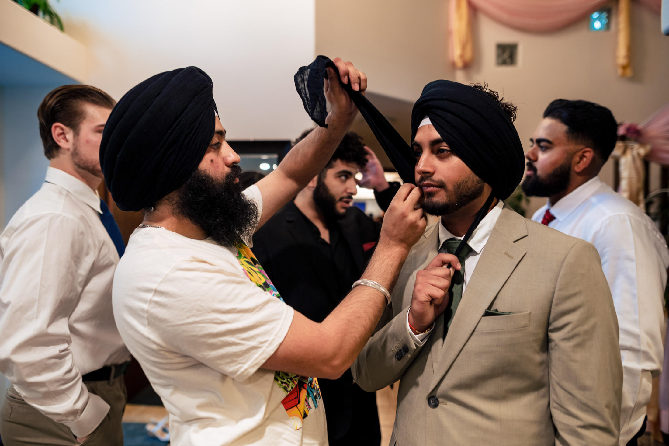 A man assists another with his turban at a Winnipeg wedding.