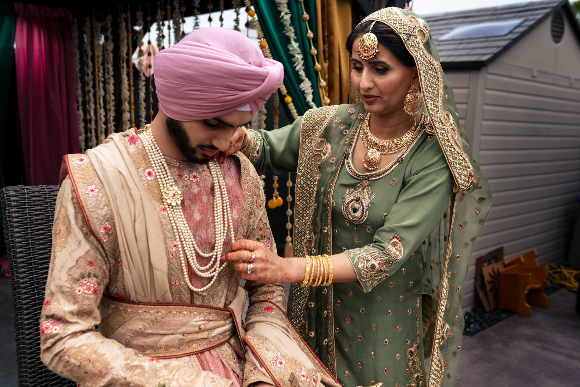 At a Winnipeg wedding, a woman adjusts a man's necklace during the ceremony.