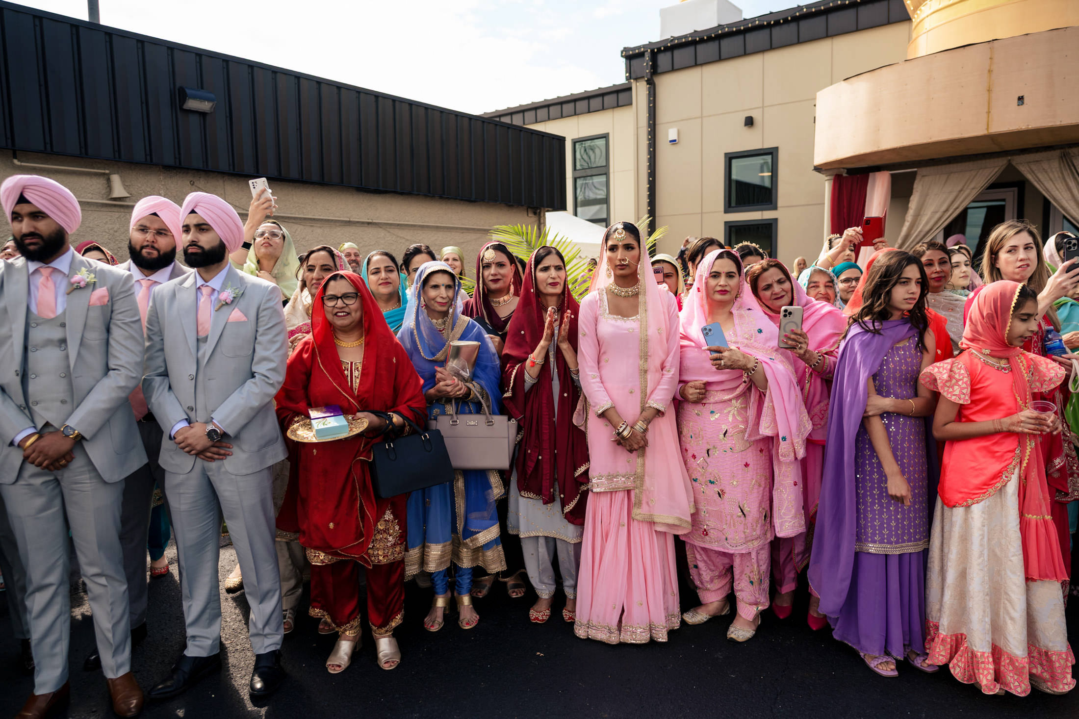 A large group in colorful traditional attire gathered for a Winnipeg wedding.