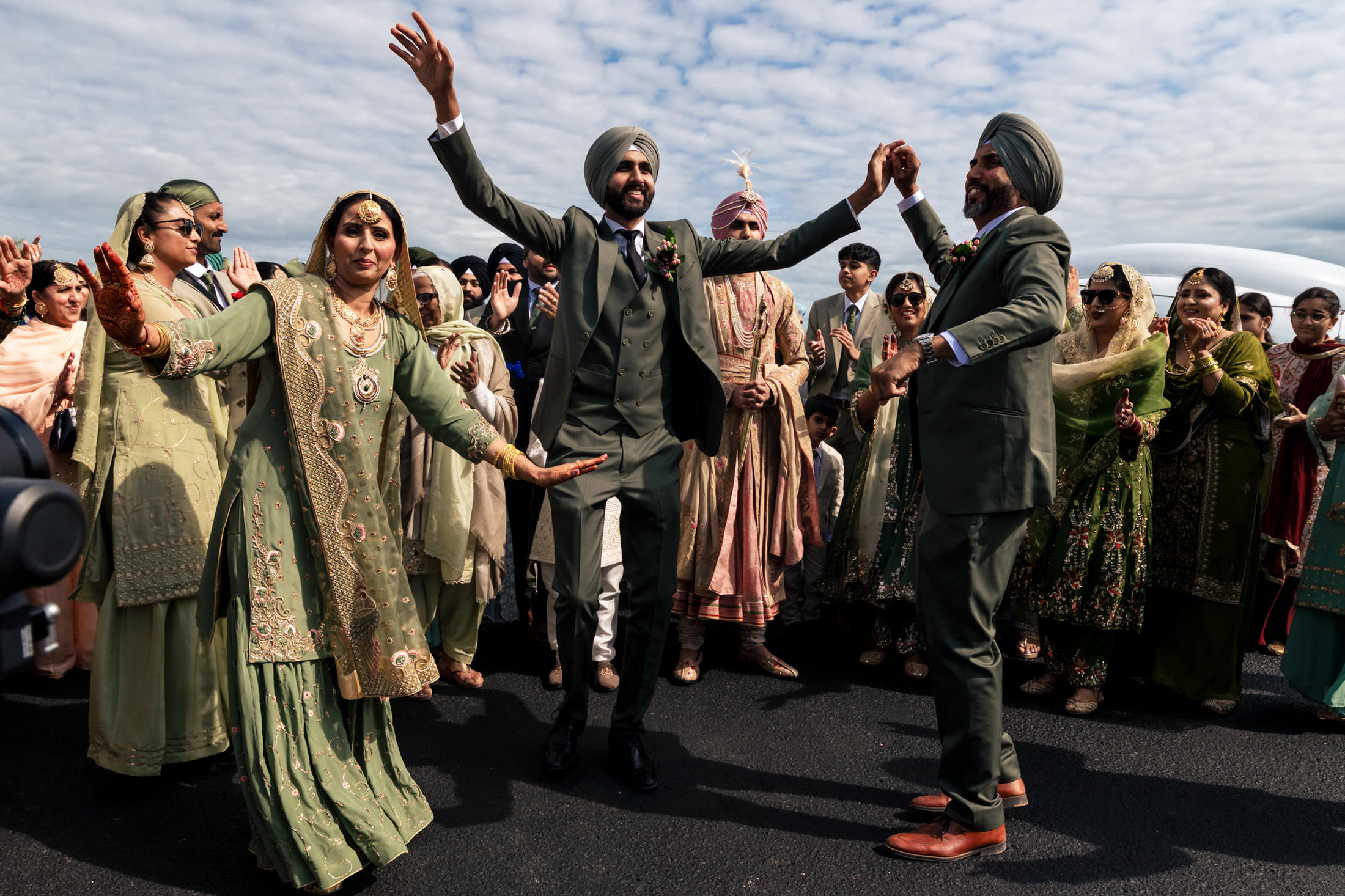 Winnipeg wedding with joyful dancing outdoors in traditional Indian attire.