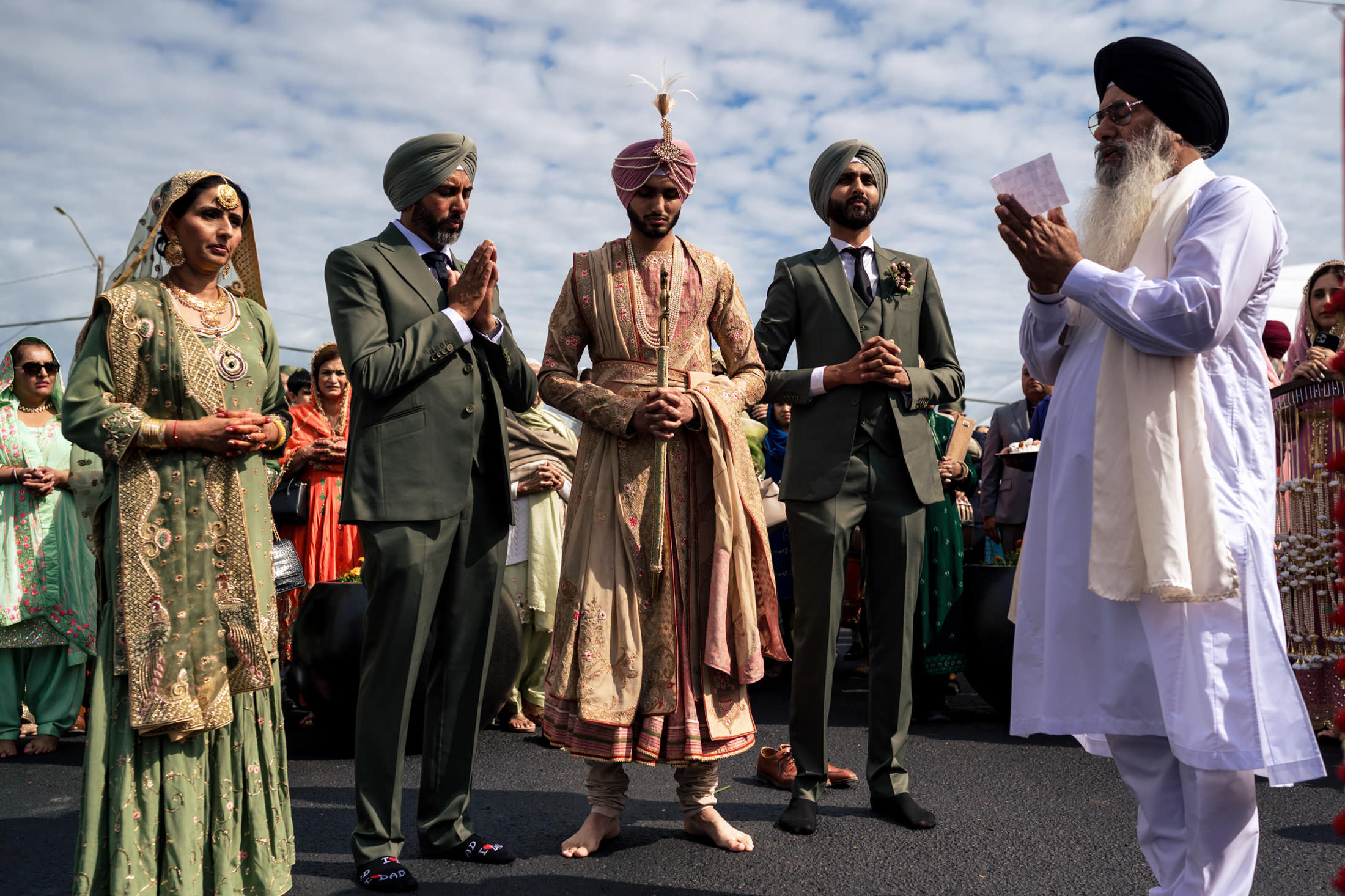A Sikh wedding in Winnipeg with traditional attire under a cloudy sky.