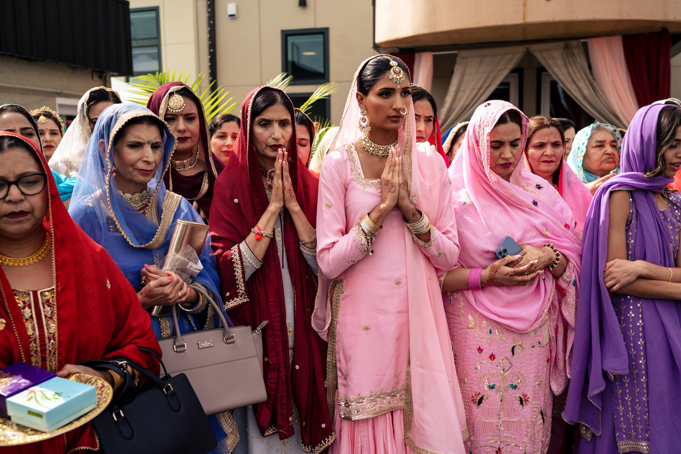 Women in colorful traditional attire at a vibrant Winnipeg wedding ceremony.