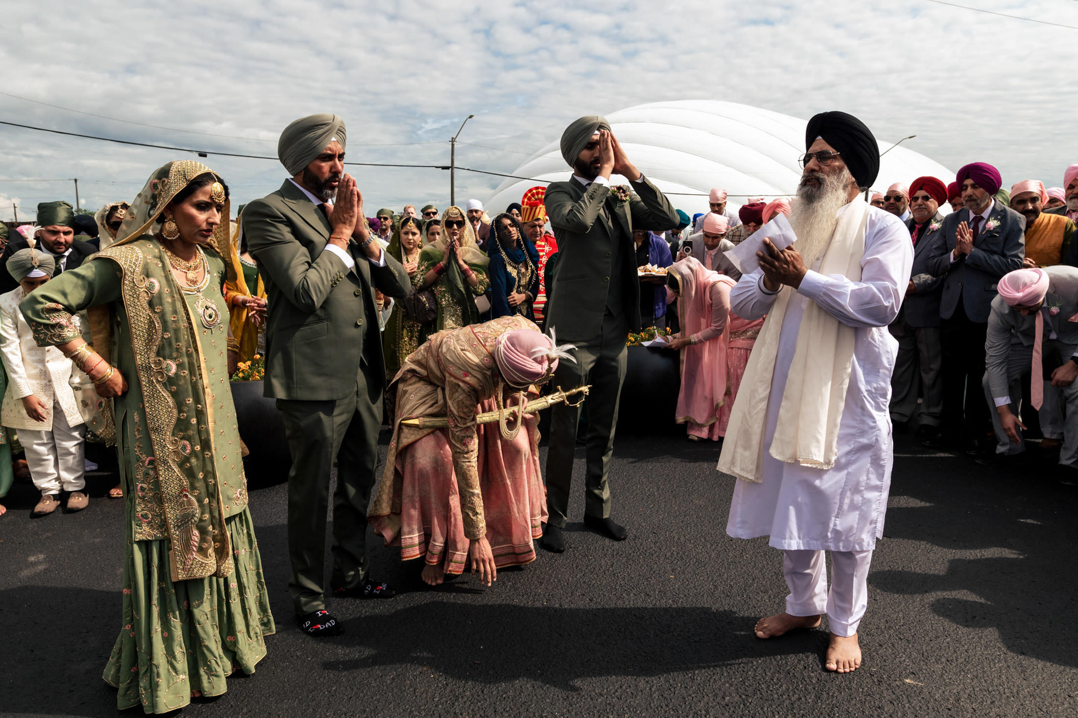 A traditional Sikh Winnipeg wedding with people in colorful attire and formal wear.