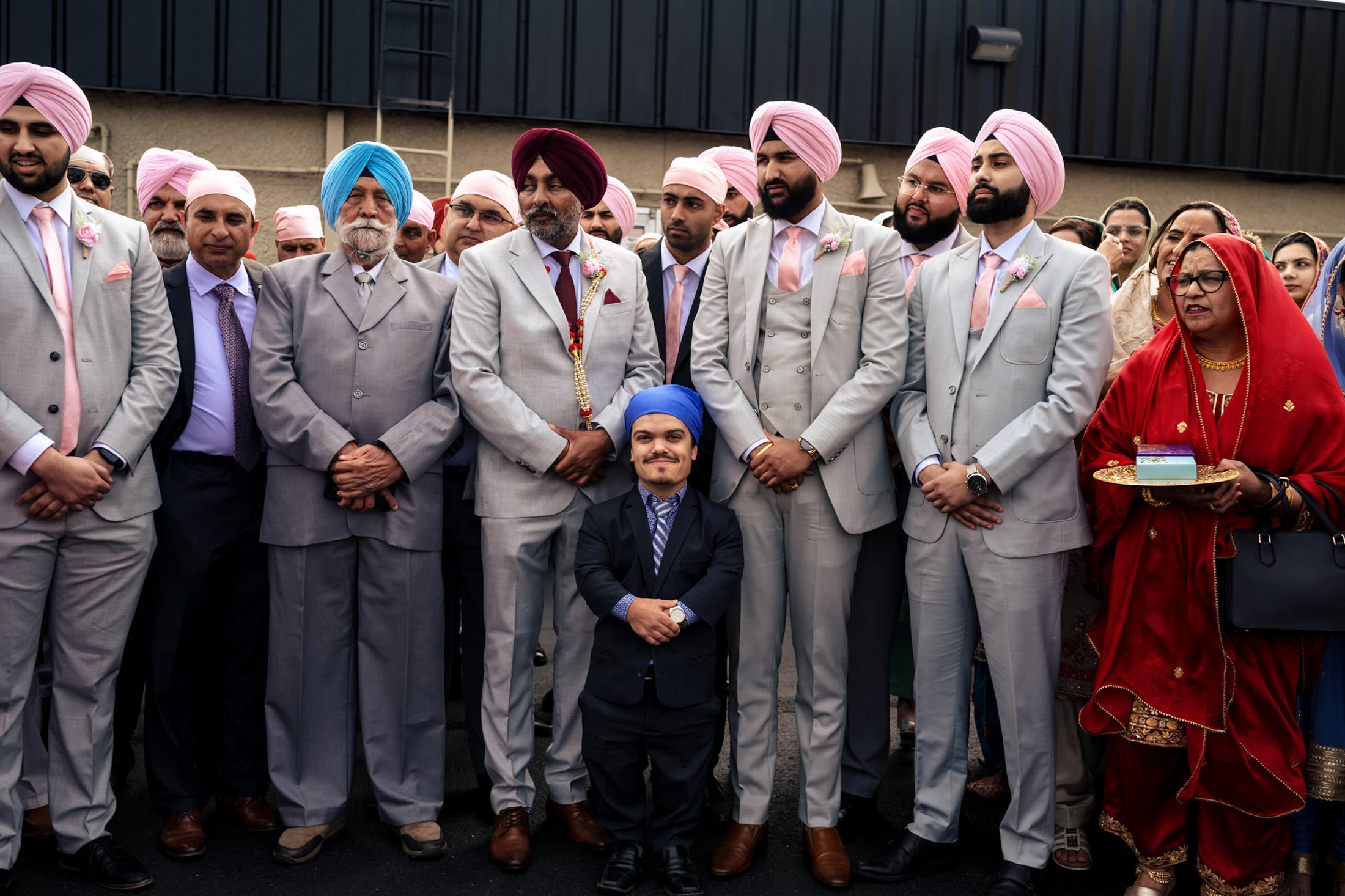 Winnipeg wedding party in formal attire, sporting colorful turbans for a photo.