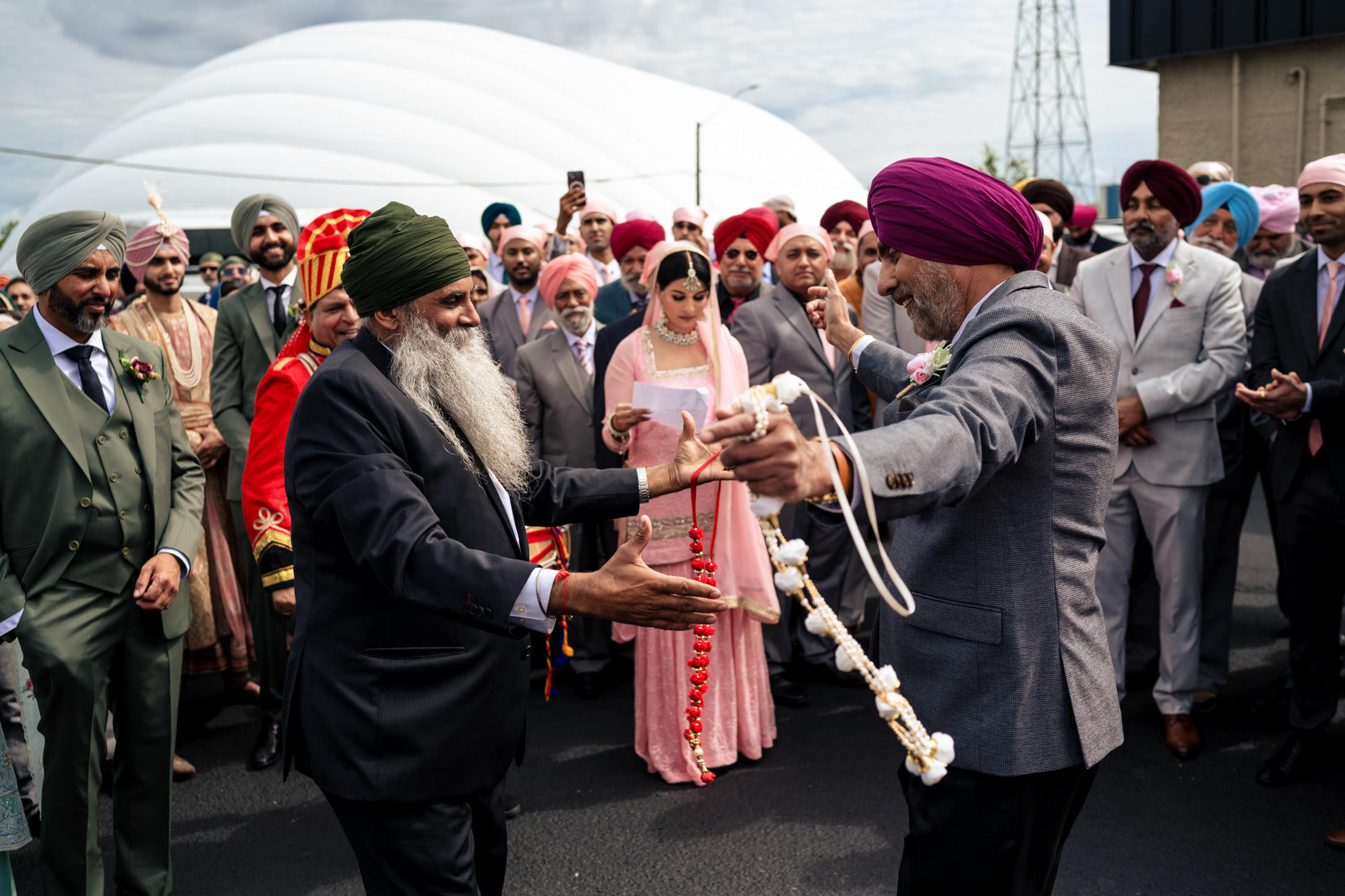 Two men in traditional attire dance joyfully at a Winnipeg wedding.