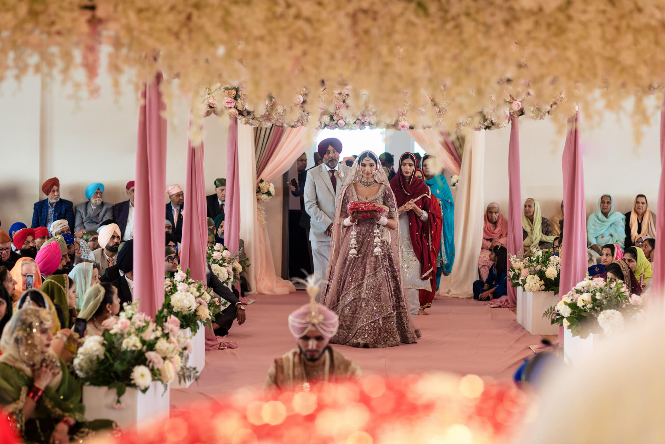Bride and groom walking down the aisle at a traditional Sikh Winnipeg wedding ceremony.