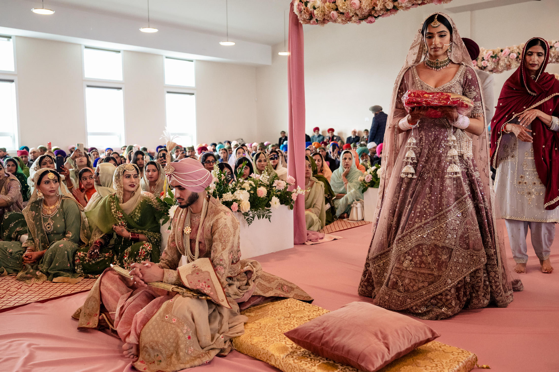 Winnipeg wedding with a bride and groom in ornate attire, surrounded by guests.