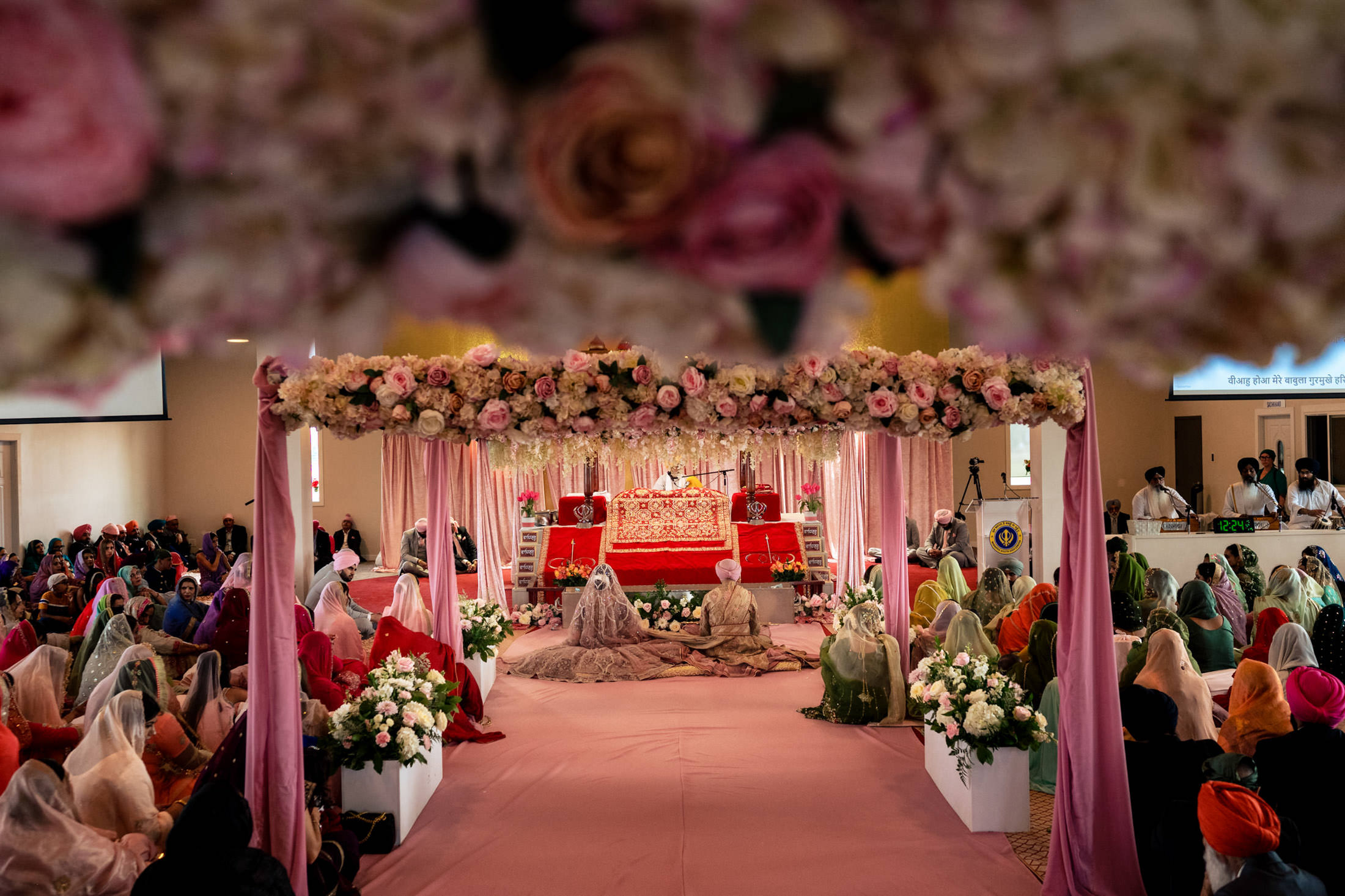 Winnipeg wedding ceremony under a floral canopy, guests gathered around.