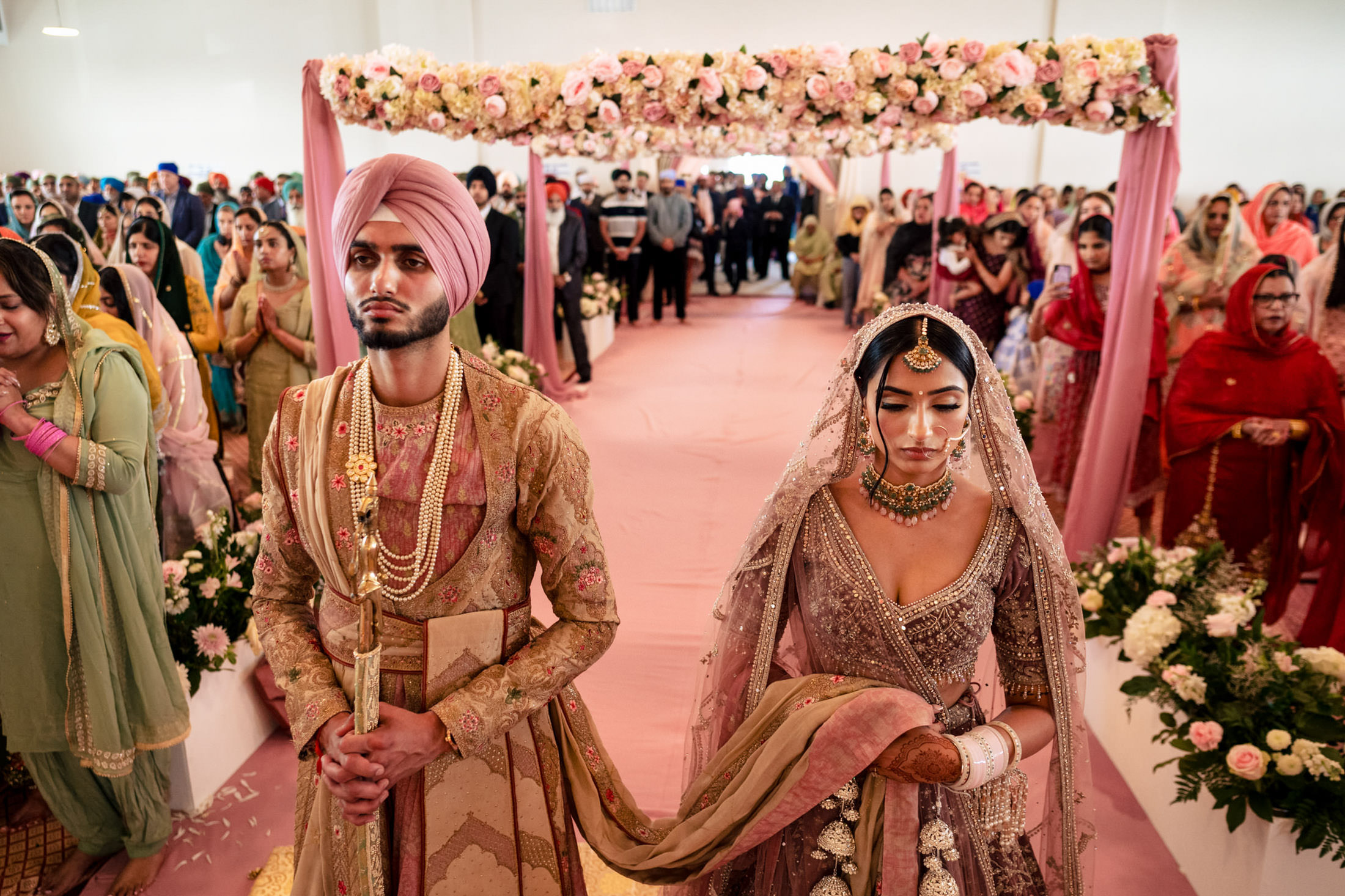 A couple in traditional attire enjoy a vibrant Winnipeg wedding ceremony.