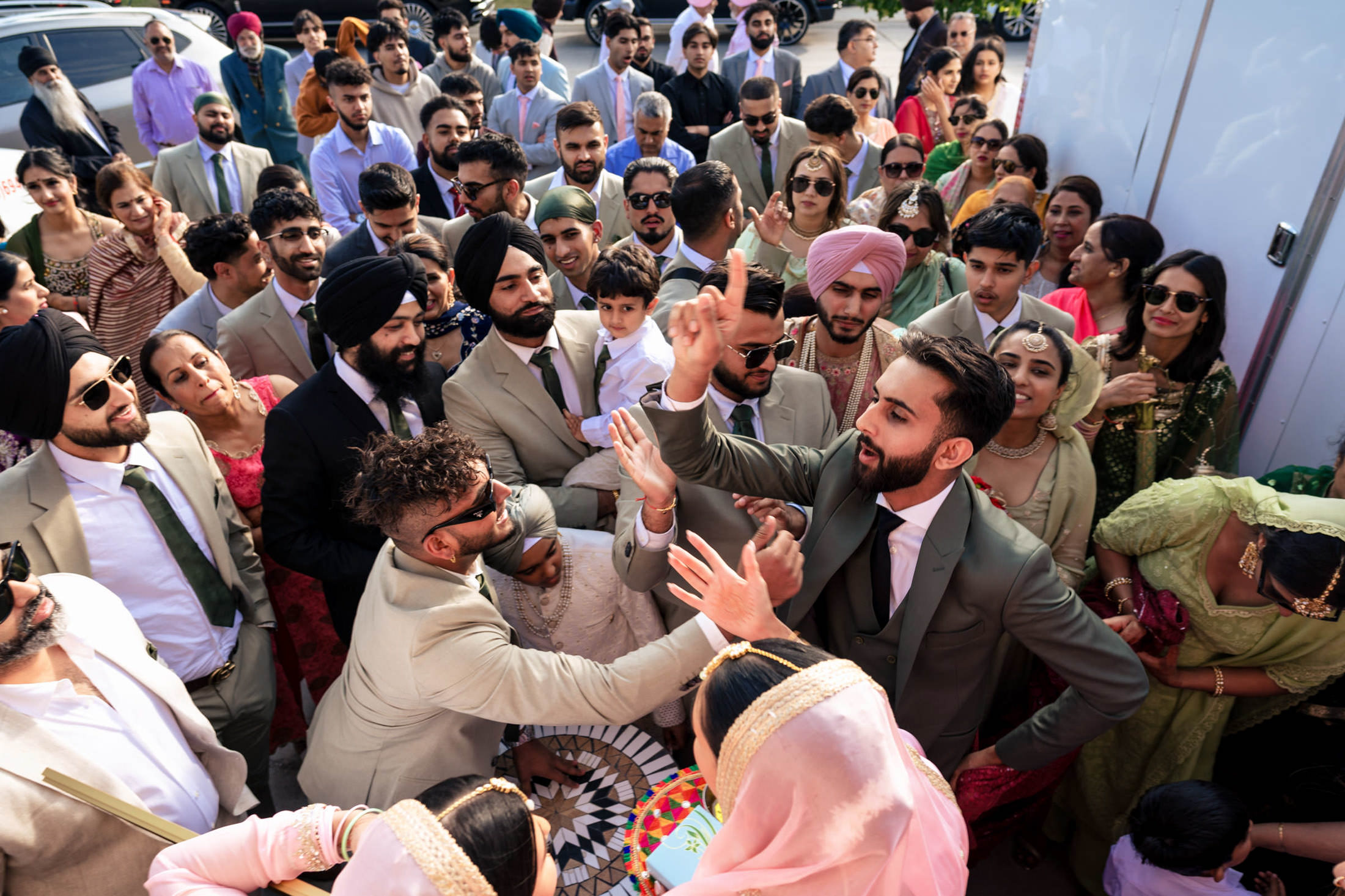 Winnipeg wedding with a group celebrating outdoors, some in traditional attire, men in suits.