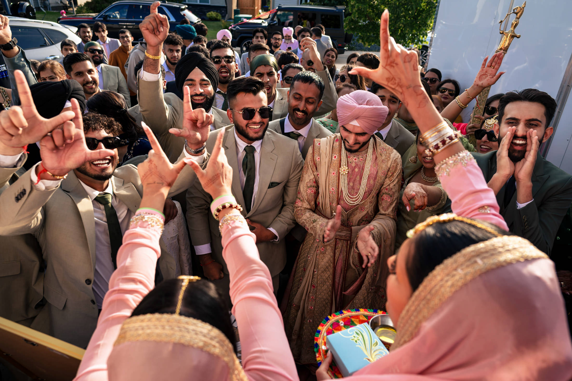 Group celebrating at a lively Winnipeg wedding with vibrant attire and joyous expressions.