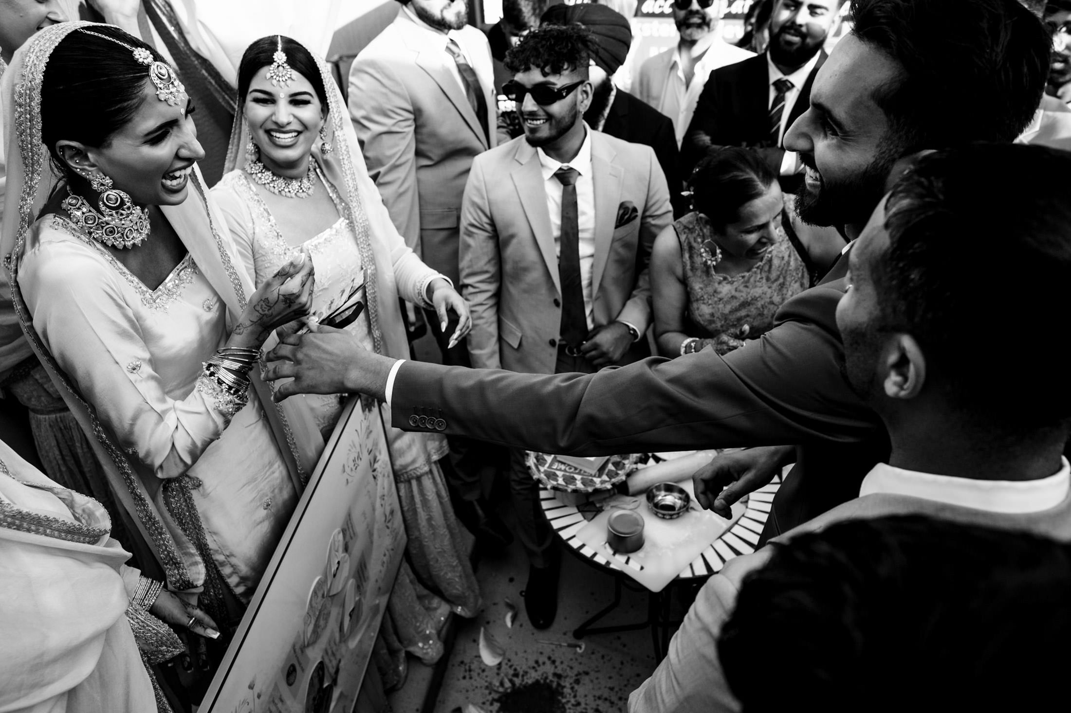 Winnipeg wedding group smiling, interacting joyfully in classic black and white.