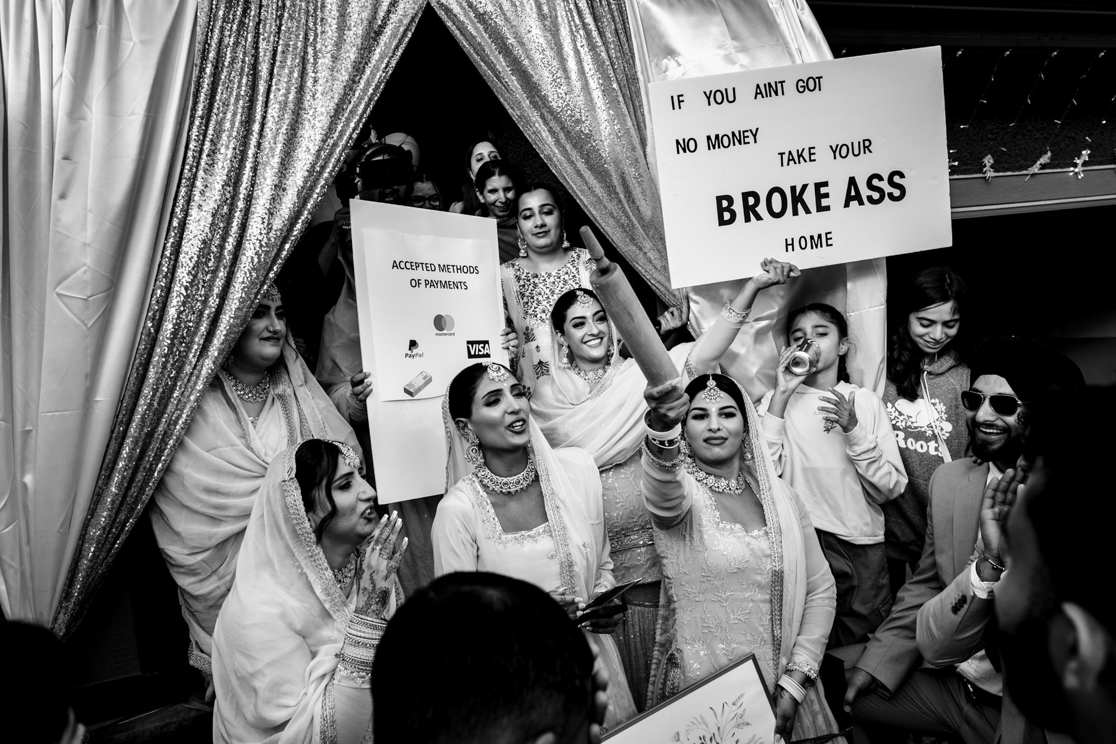 Group at a Winnipeg wedding, laughing and holding signs about money.