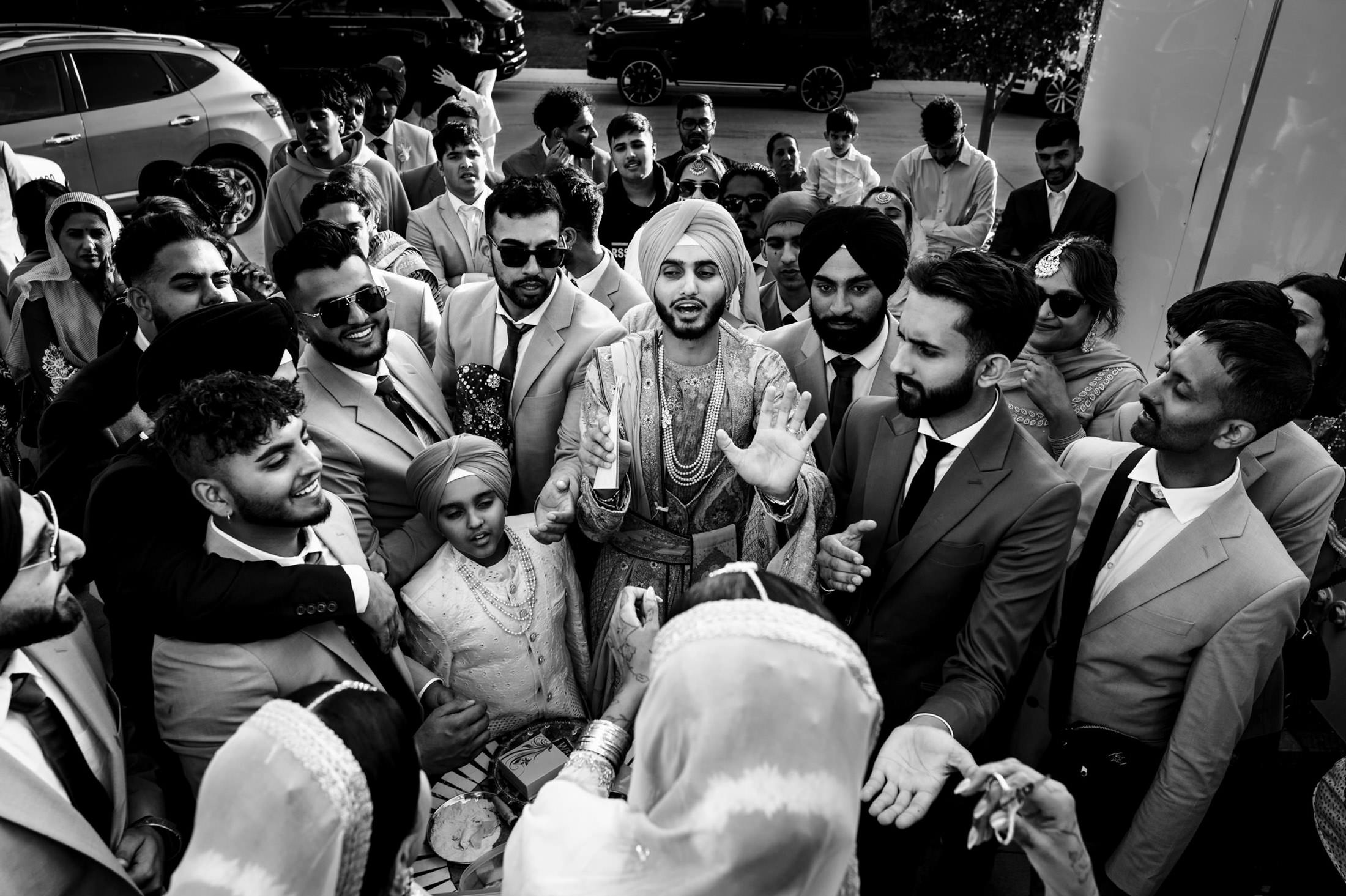 A group celebrates at a Winnipeg wedding, joyfully interacting in traditional attire.