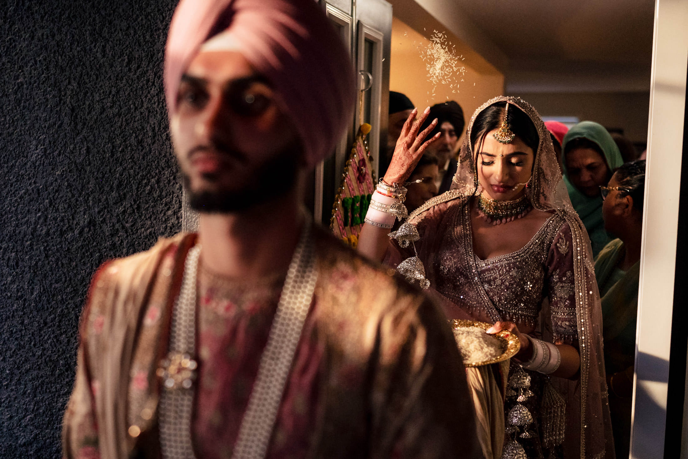 Bride in ornate attire performs a Winnipeg wedding ceremony while groom walks ahead.