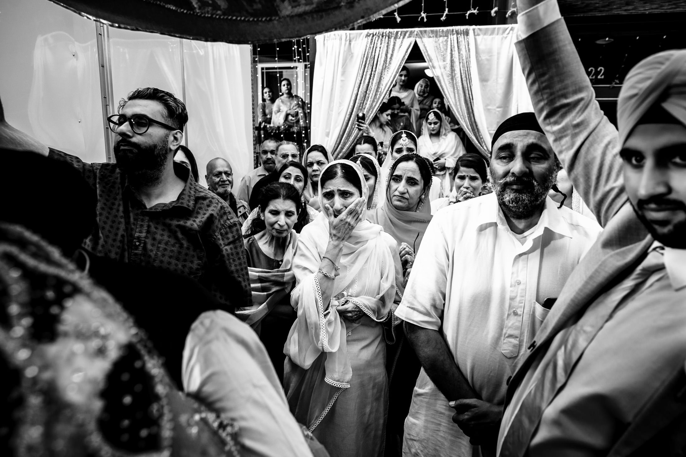 A Winnipeg wedding gathering captured in a black-and-white photo with emotional expressions.