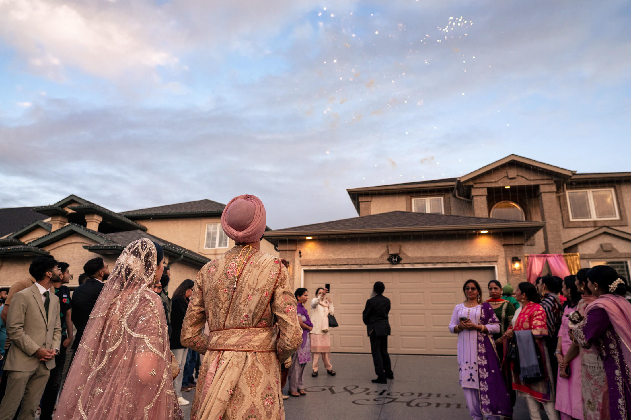 People in traditional attire watch fireworks at a Winnipeg wedding celebration.