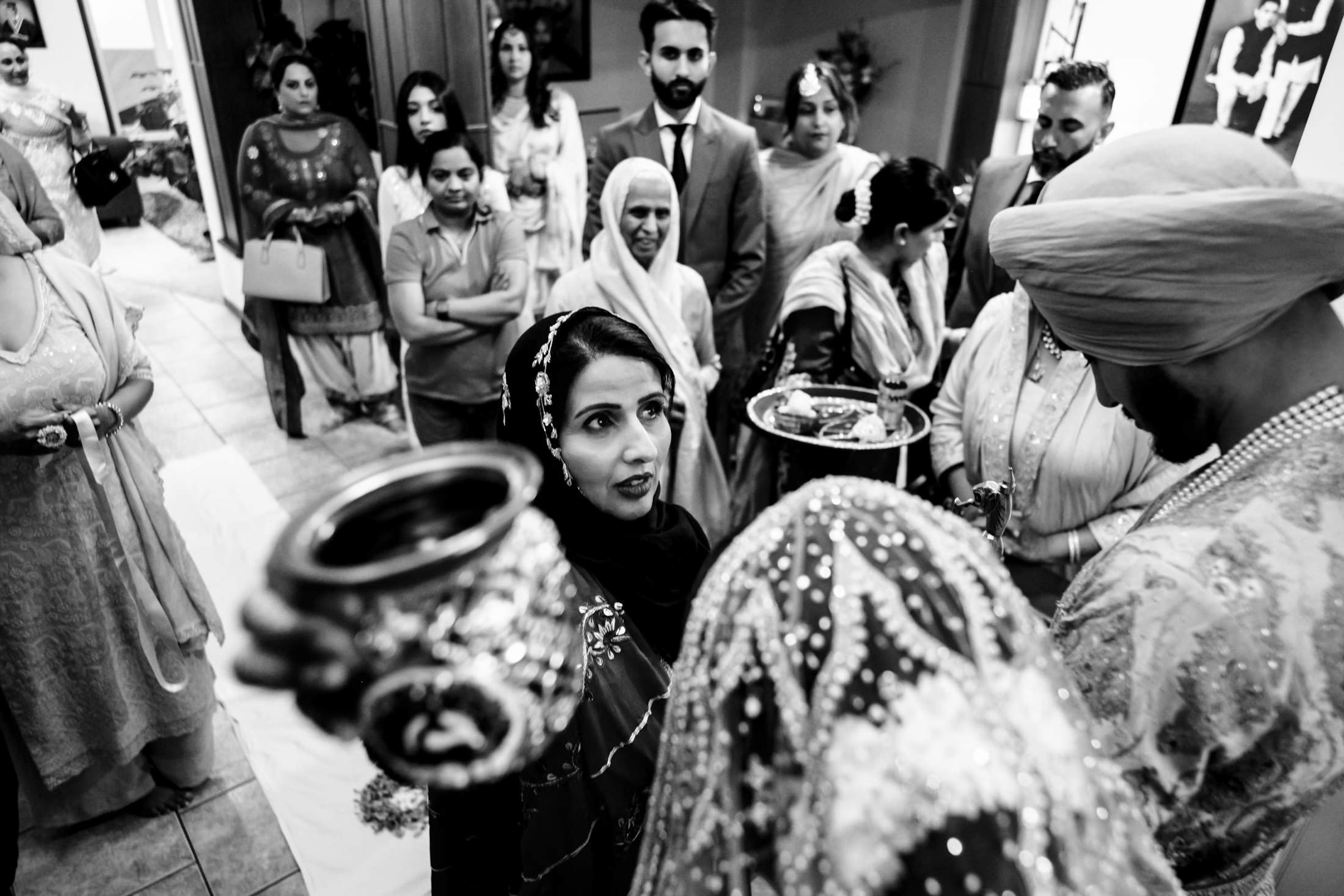 Winnipeg wedding guests in traditional attire at a cultural ceremony with decorative items.