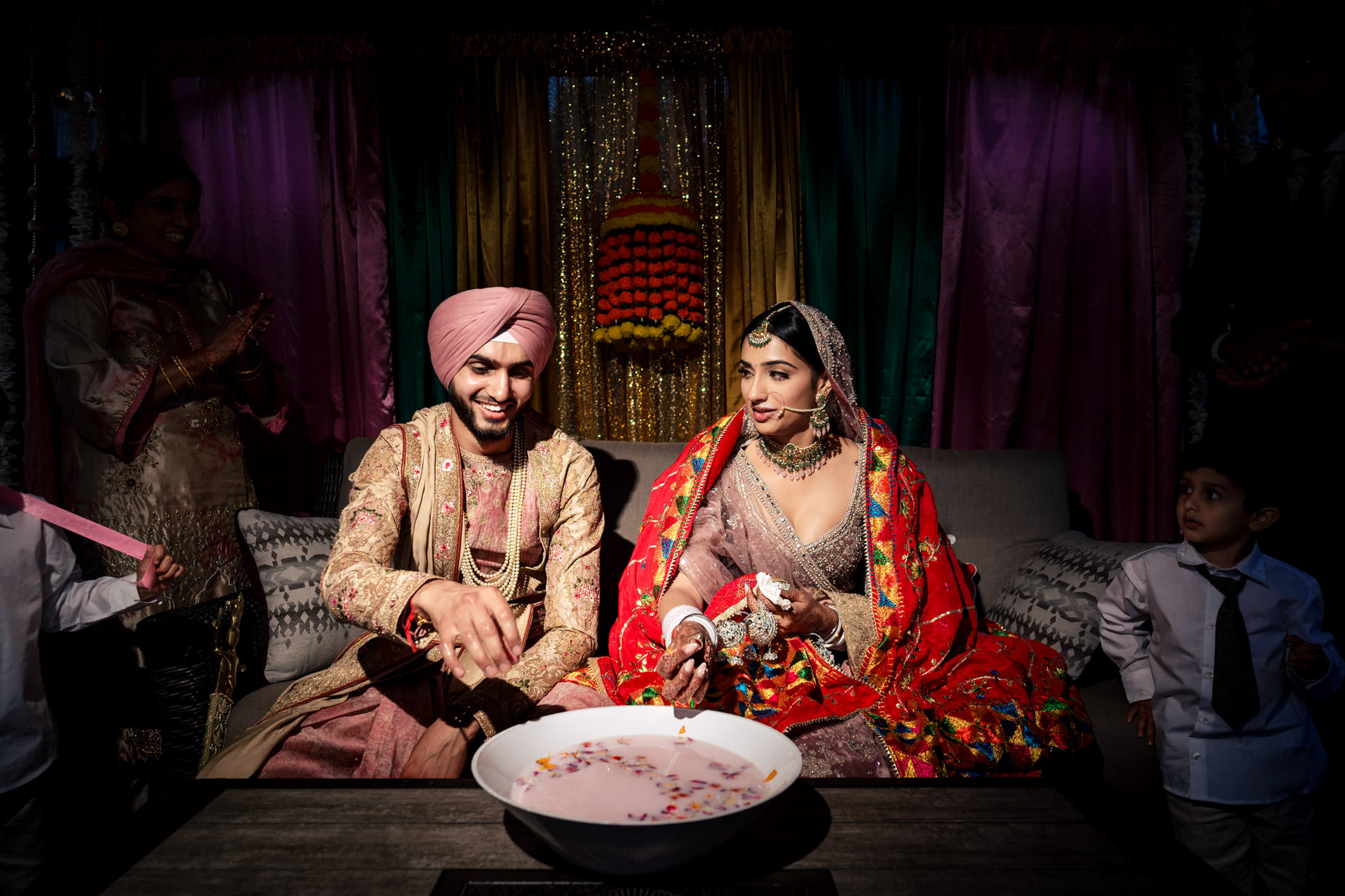 Bride and groom in traditional attire during a Winnipeg wedding, with onlookers around.