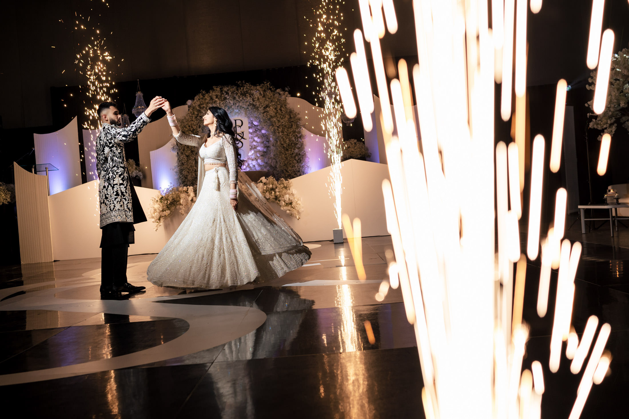 A couple dances amid sparkler effects at a beautifully decorated Winnipeg wedding venue.